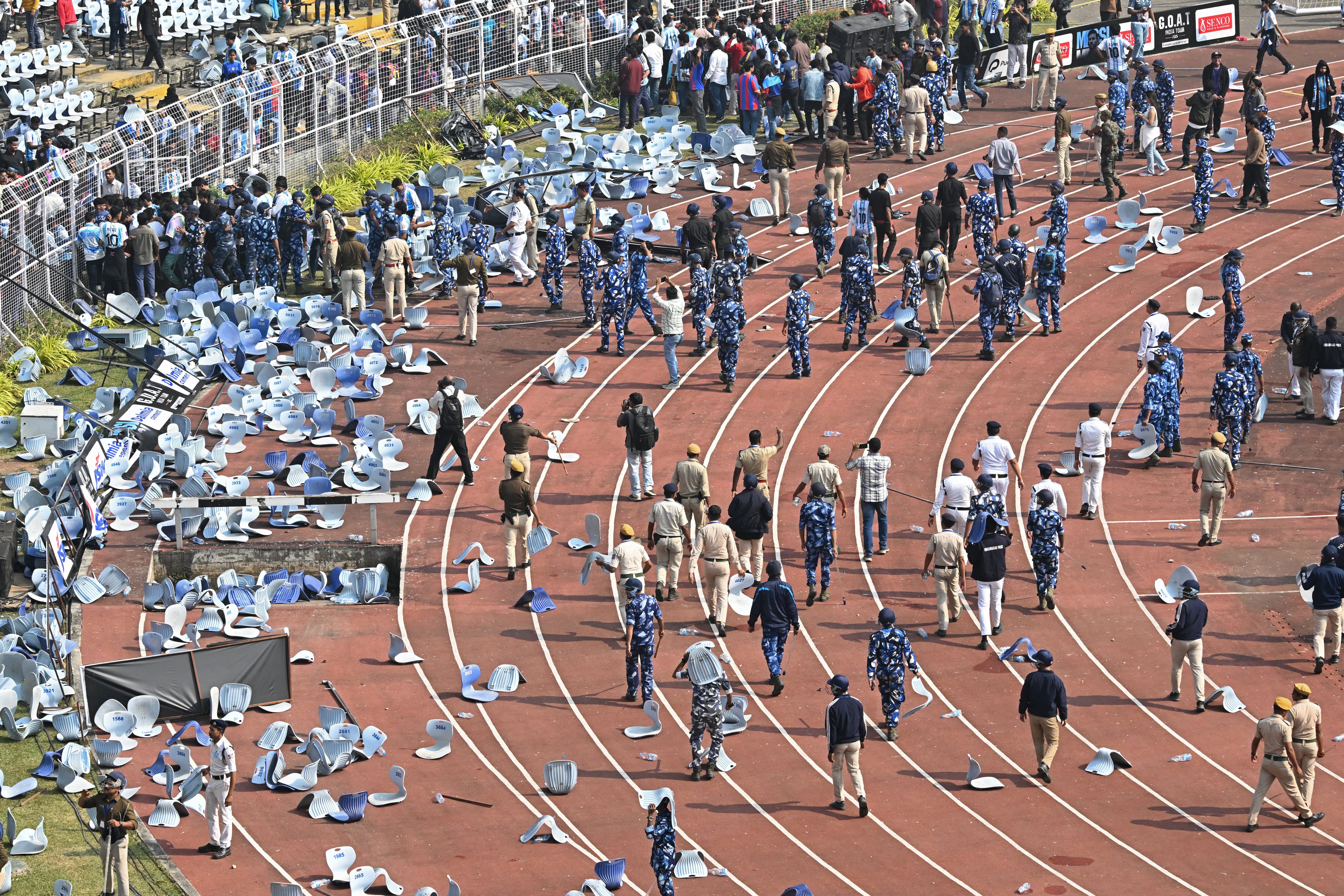 El personal de seguridad intenta controlar a los fanáticos mientras el delantero argentino del Inter Miami, #10 Lionel Messi, se retira del estadio Salt Lake, en Calcuta, el 13 de diciembre de 2025. Miles de fanáticos colmaron un estadio del este de la India ese día para aclamar a Lionel Messi, durante la inauguración de una estatua de 21 metros de altura en su honor.