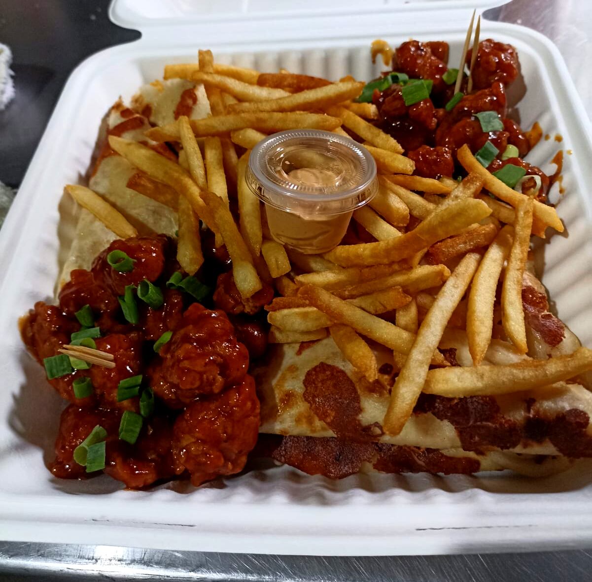 En la imagen, un empaque de cartón con pollo estilo boneless y papas fritas