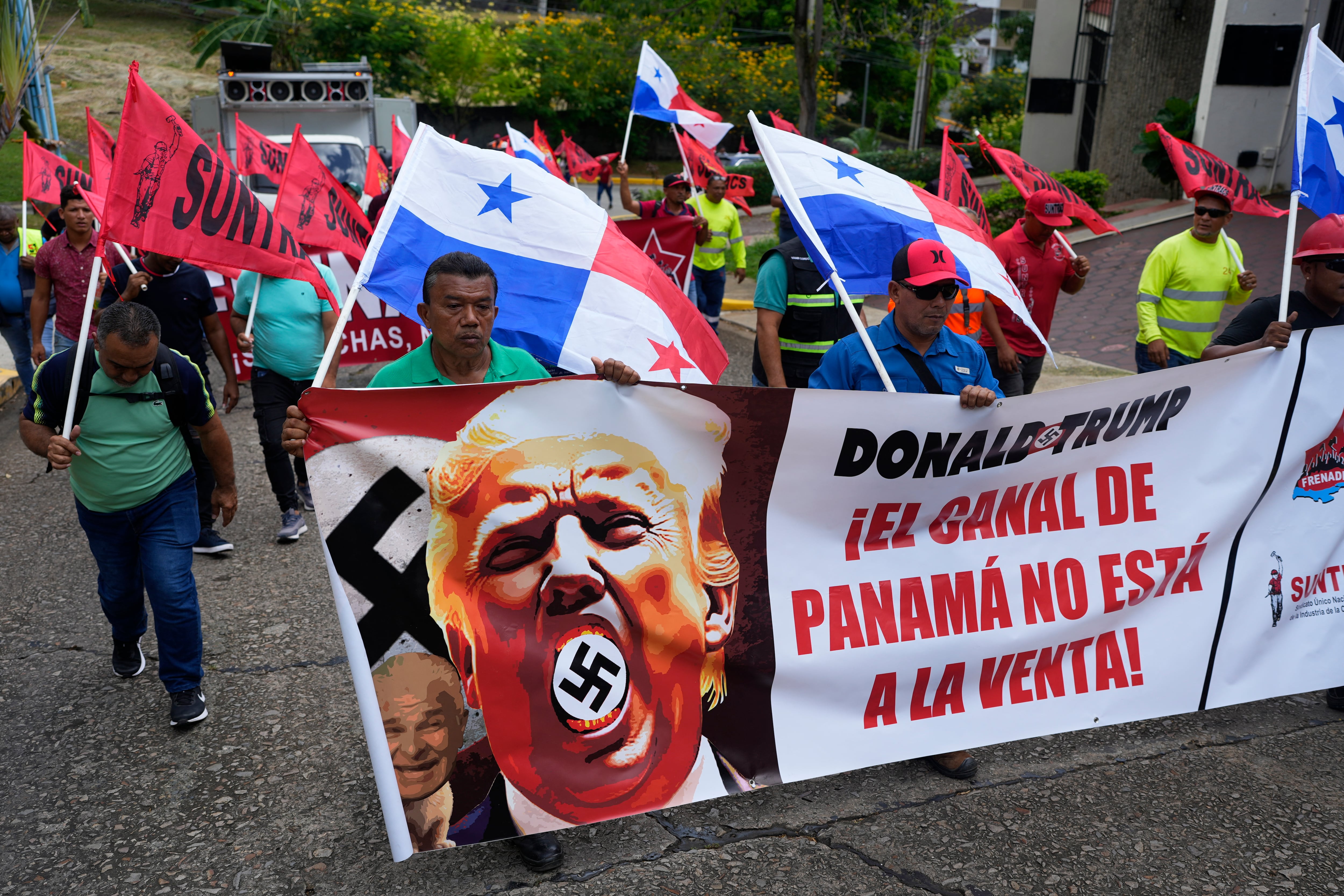 Manifestantes sostienen una pancarta que dice 'El Canal de Panamá no está a la venta' con una imagen del presidente estadounidense Donald Trump con una esvástica durante una protesta contra su toma de posesión en la Ciudad de Panamá afuera de la residencia del embajador de Estados Unidos en la Ciudad de Panamá.