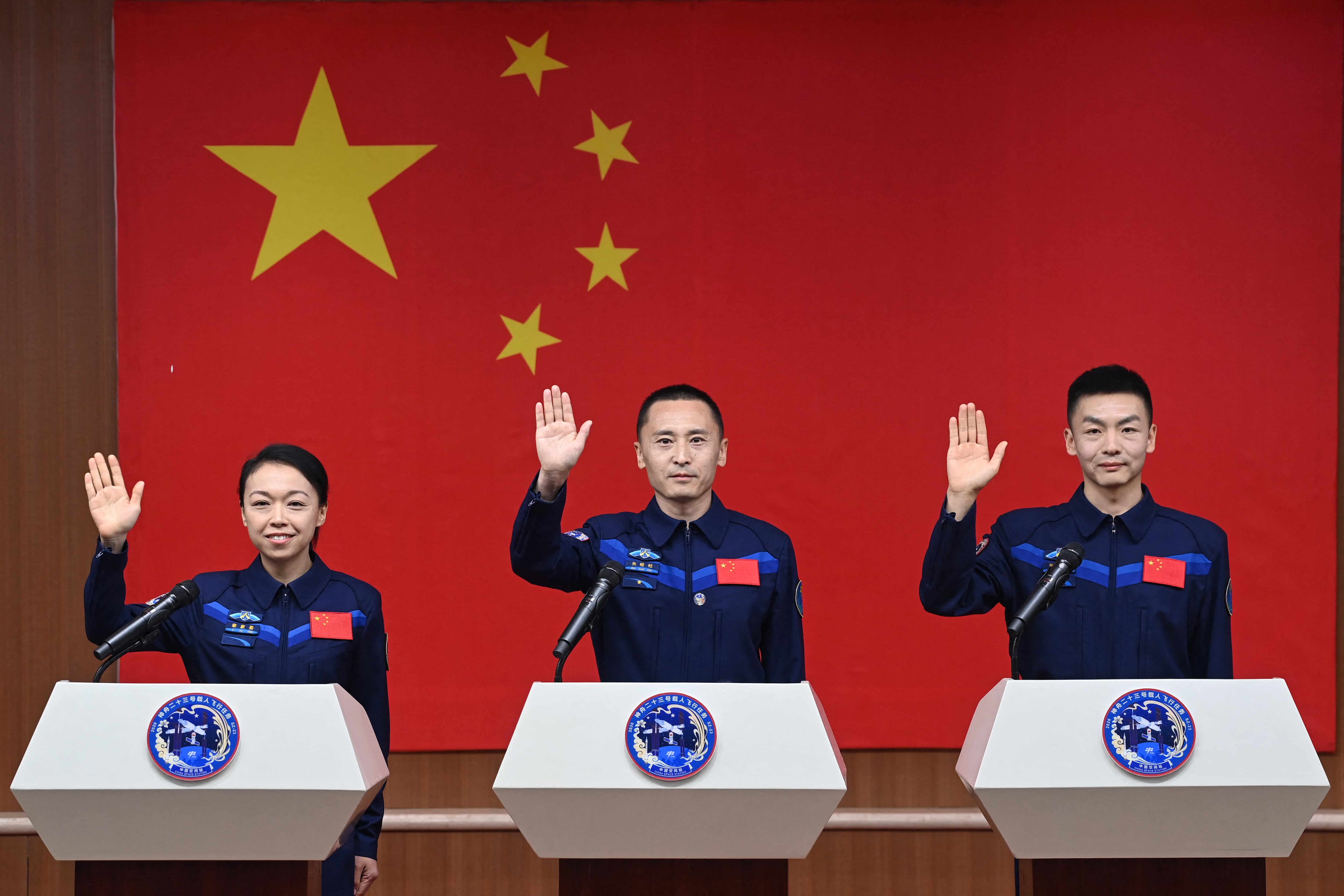 En la imagen, Los astronautas de la misión espacial Shenzhou-23 de China Lai Ka-ying (izquierda), Zhu Yangzhu (centro) y Zhang Zhiyuan (derecha) saludan durante una conferencia de prensa antes del lanzamiento de la misión en el Centro de Lanzamiento de Satélites de Jiuquan