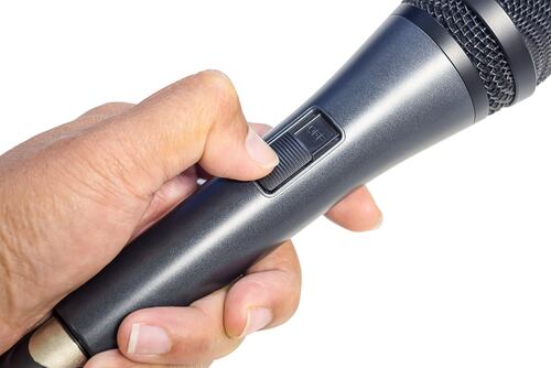 Micrófono apagado simbolizando el silencio político frente al megáfono del discurso gubernamental.