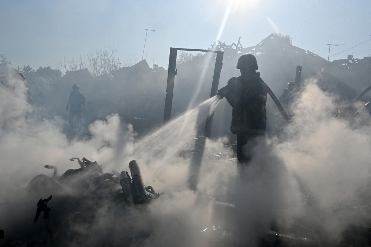 Un bombero apaga un incendio en viviendas particulares tras un ataque ruso con una bomba aérea guiada que dejó una persona muerta, en medio de la invasión rusa de Ucrania, en Járkov, el 11 de octubre de 2026.