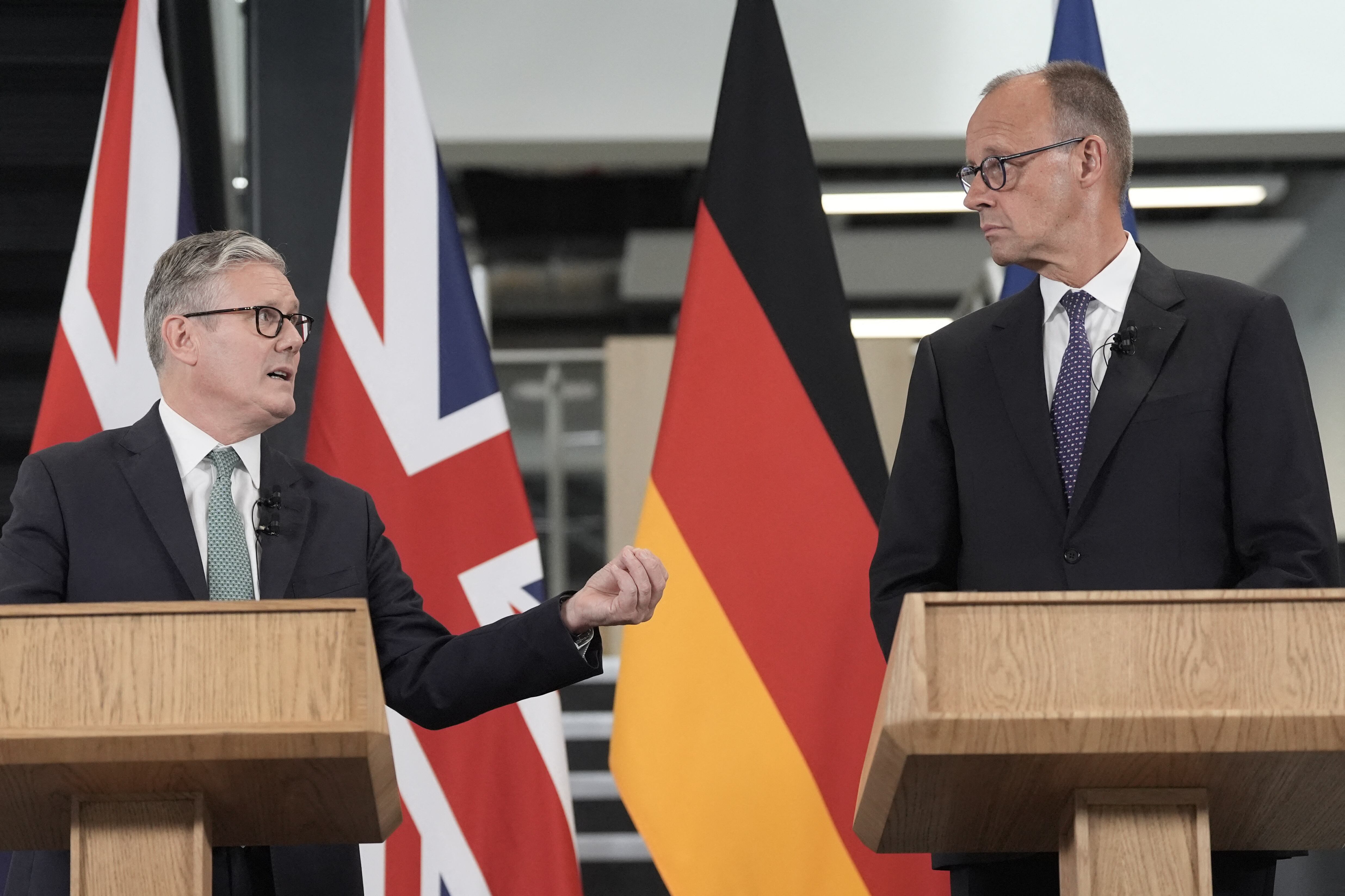 El primer ministro británico Keir Starmer (izquierda) y el canciller alemán Friedrich Merz (derecha) ofrecen una conferencia de prensa durante su visita a las instalaciones de Airbus en Stevenage, en el sur de Inglaterra, el 17 de julio de 2025, tras la firma de un tratado de cooperación bilateral. (Foto de Stefan Rousseau / POOL / AFP)