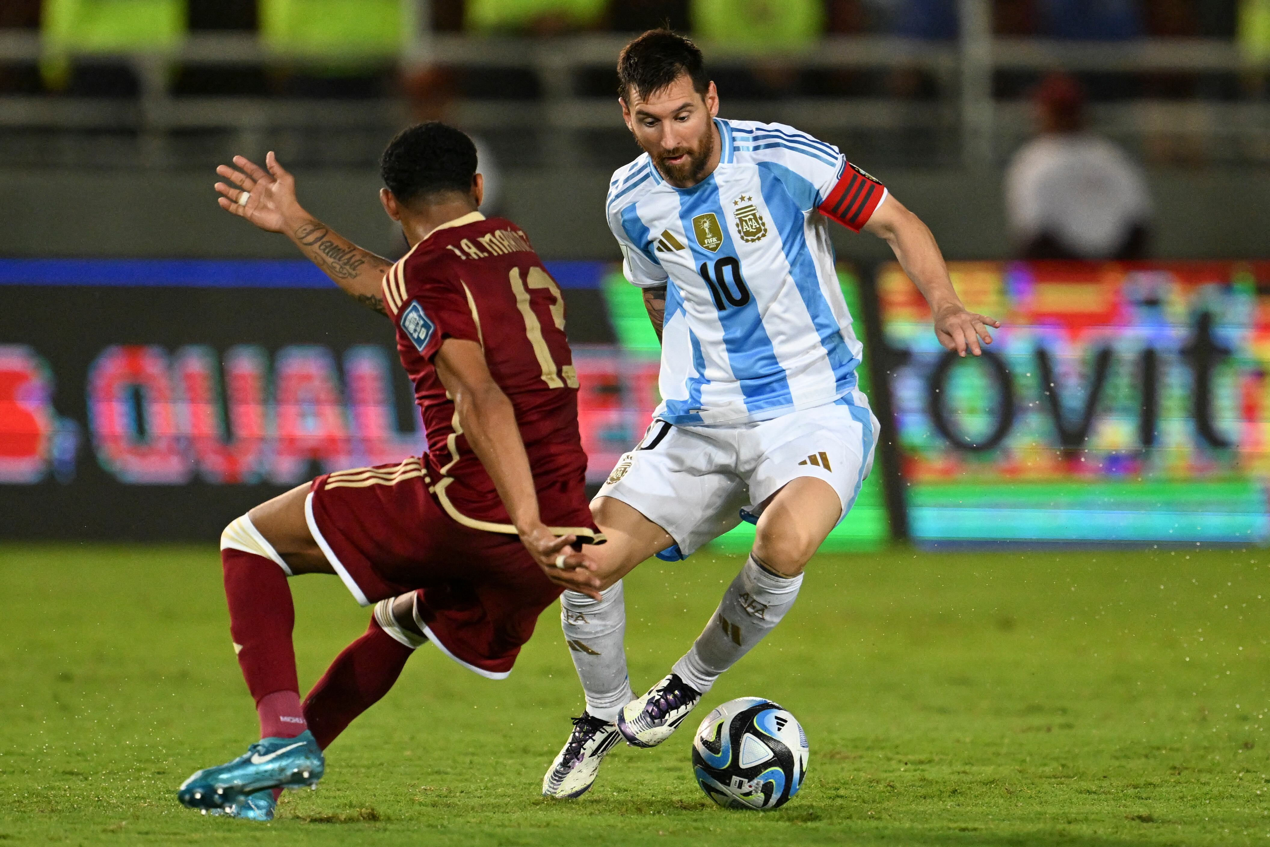 Argentina's forward Lionel Messi (R) and Venezuela's midfielder Jose Martinez fight for the ball during the 2026 FIFA World Cup South American qualifiers football match between Venezuela and Argentina, at the Monumental de Maturin stadium in Maturin, Venezuela, on October 10, 2024. (Photo by JUAN BARRETO / AFP)