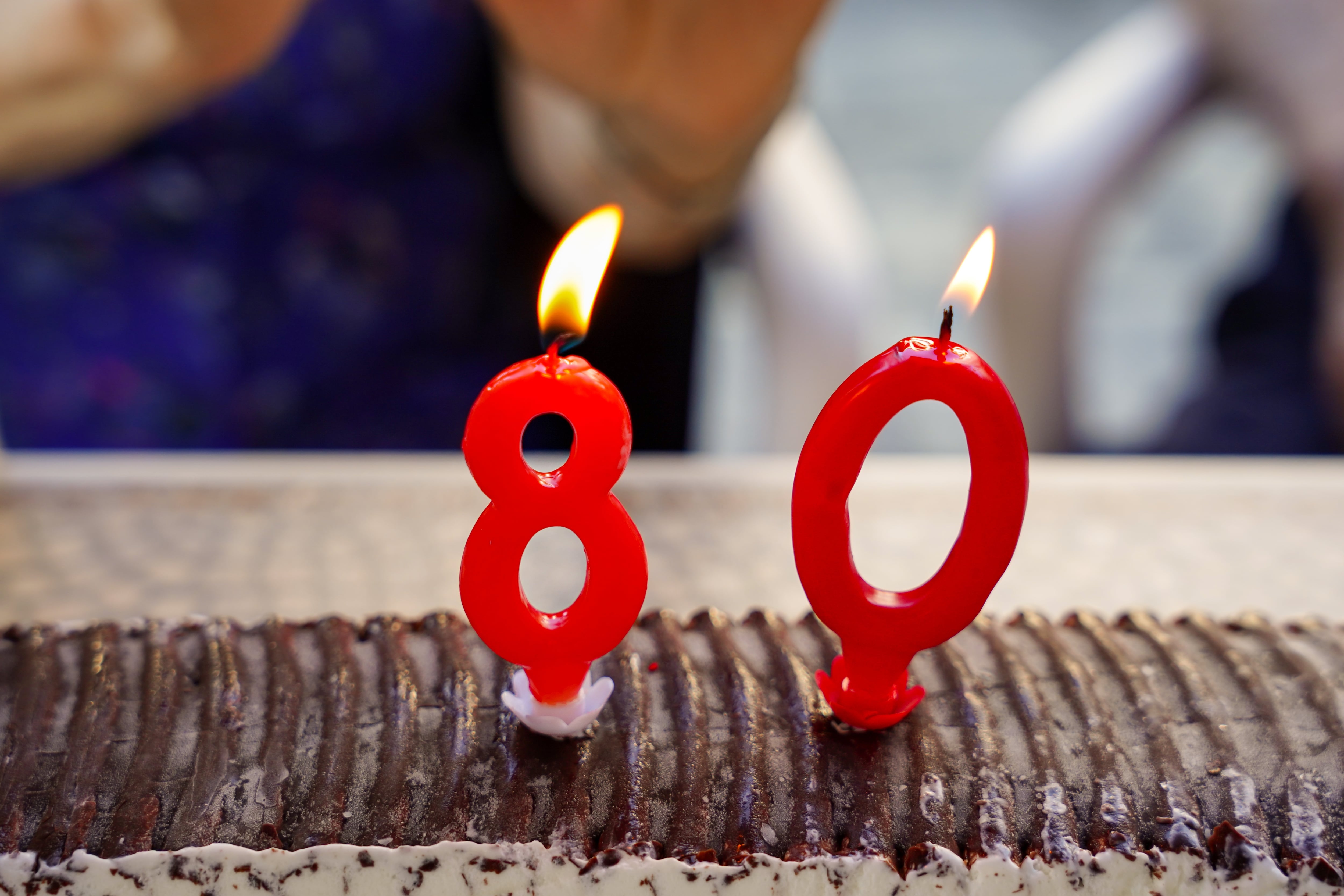 Un pastel de cumpleaños con velas que indican el cumpleaños número 80.
