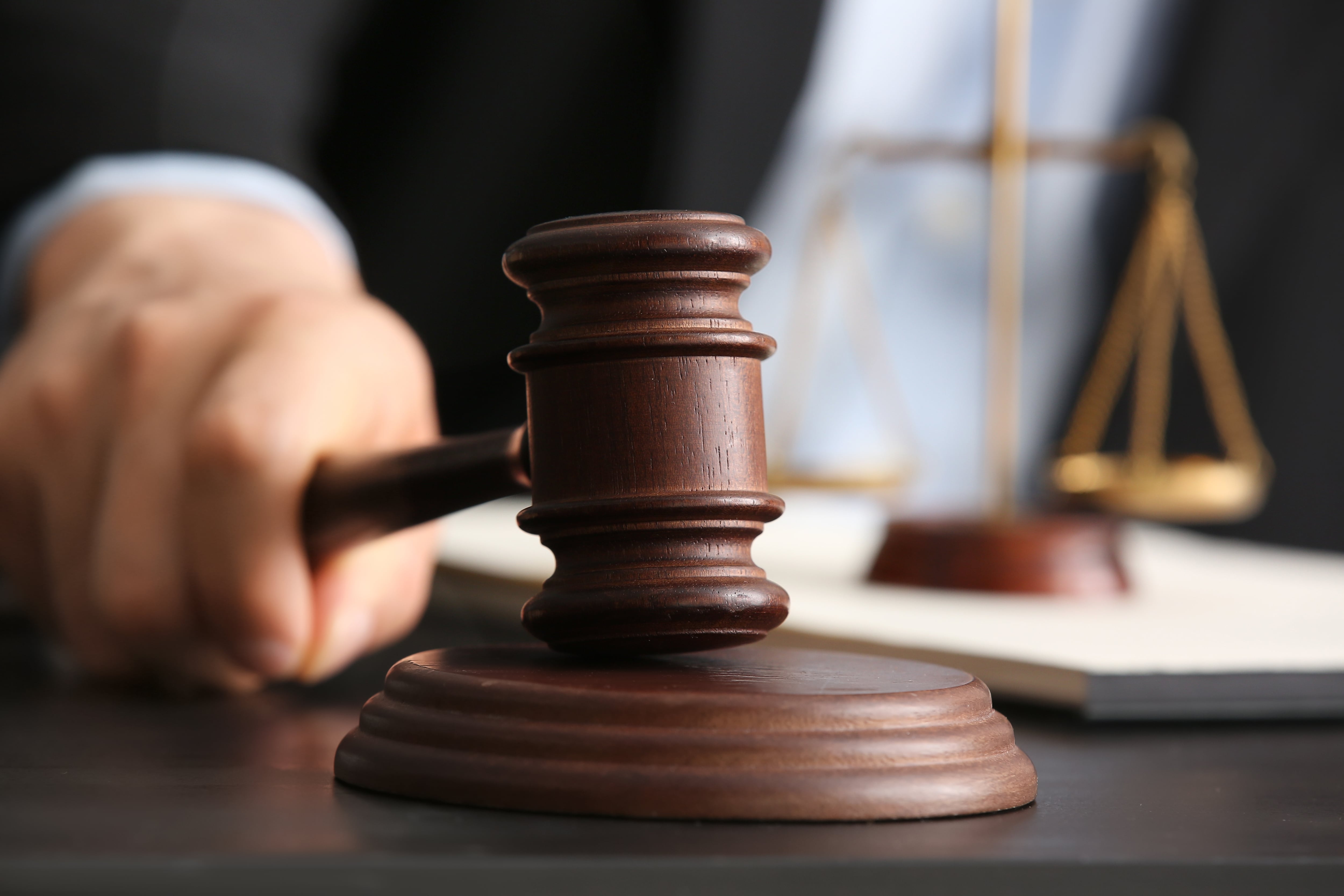 Primer plano de mano con mazo de juez, golpe de mazo judicial, justicia pronta, juicios