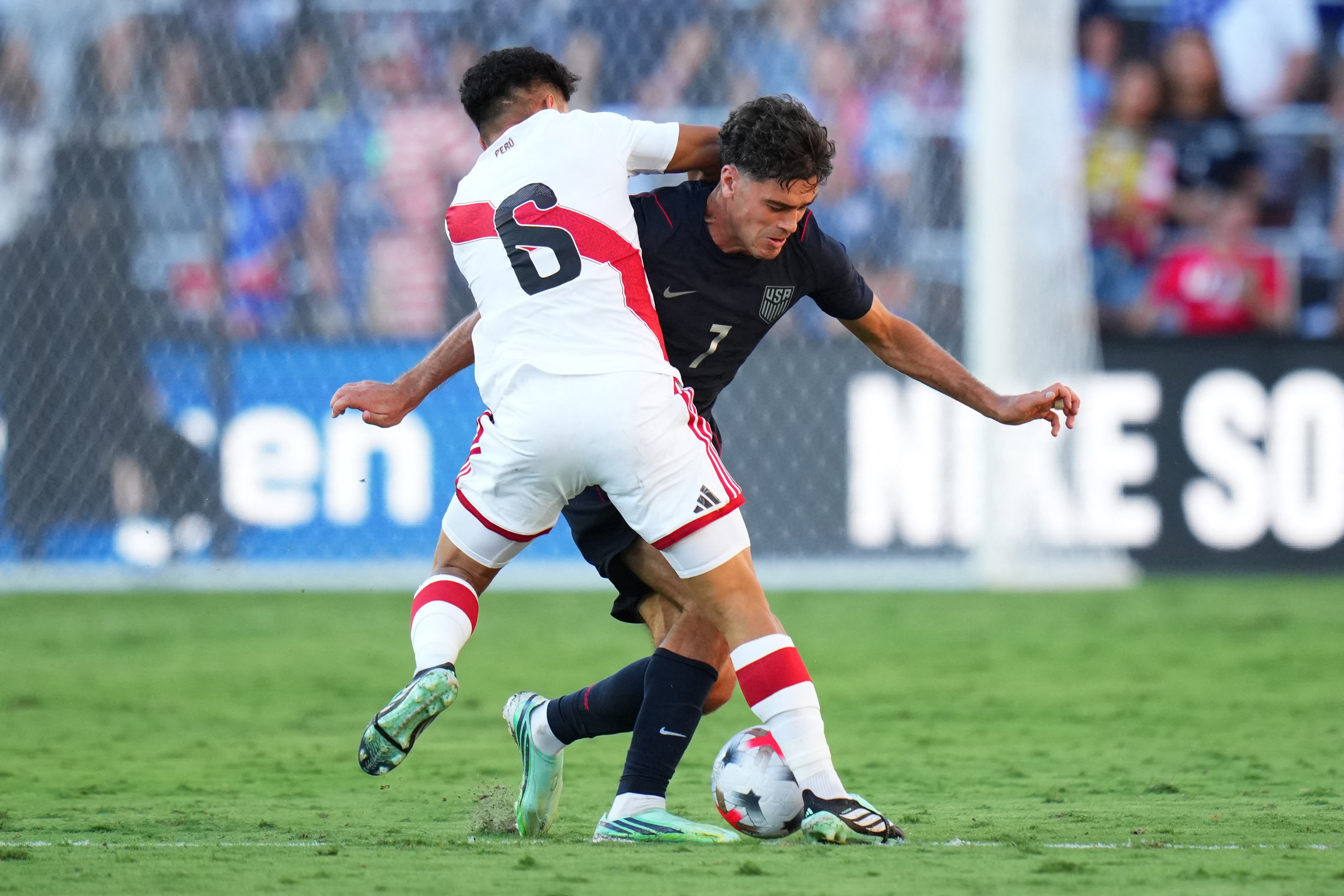 Giovanni Reyna, de Estados Unidos, disputa el balón con el peruano Jesús Pretell durante este amistoso disputado en Orlando.