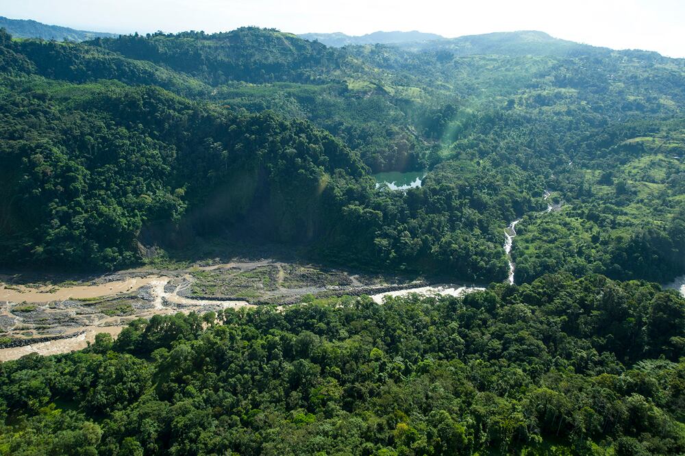 Vista de uno de dos cuerpos de agua de las Lagunas Lancaster junto al cauce del río Reventazón, en Siquirres de Limón. En el centro de la imagen se ve un boquete en la montaña de donde supuestamente se extrajo  material de la ladera, según denuncias de los quejosos. Las lagunas, declaradas humedales en 1994, son  hábitat para distintas formas de vida silvestre en la zona y es una nueva ruta de paso de distintas especies en sus ciclos migratorio sobre el Sub-corredor Biológico Barbilla Destierro  .  | KURT Y ALEXANDRA GRUENINGER PARA LN.