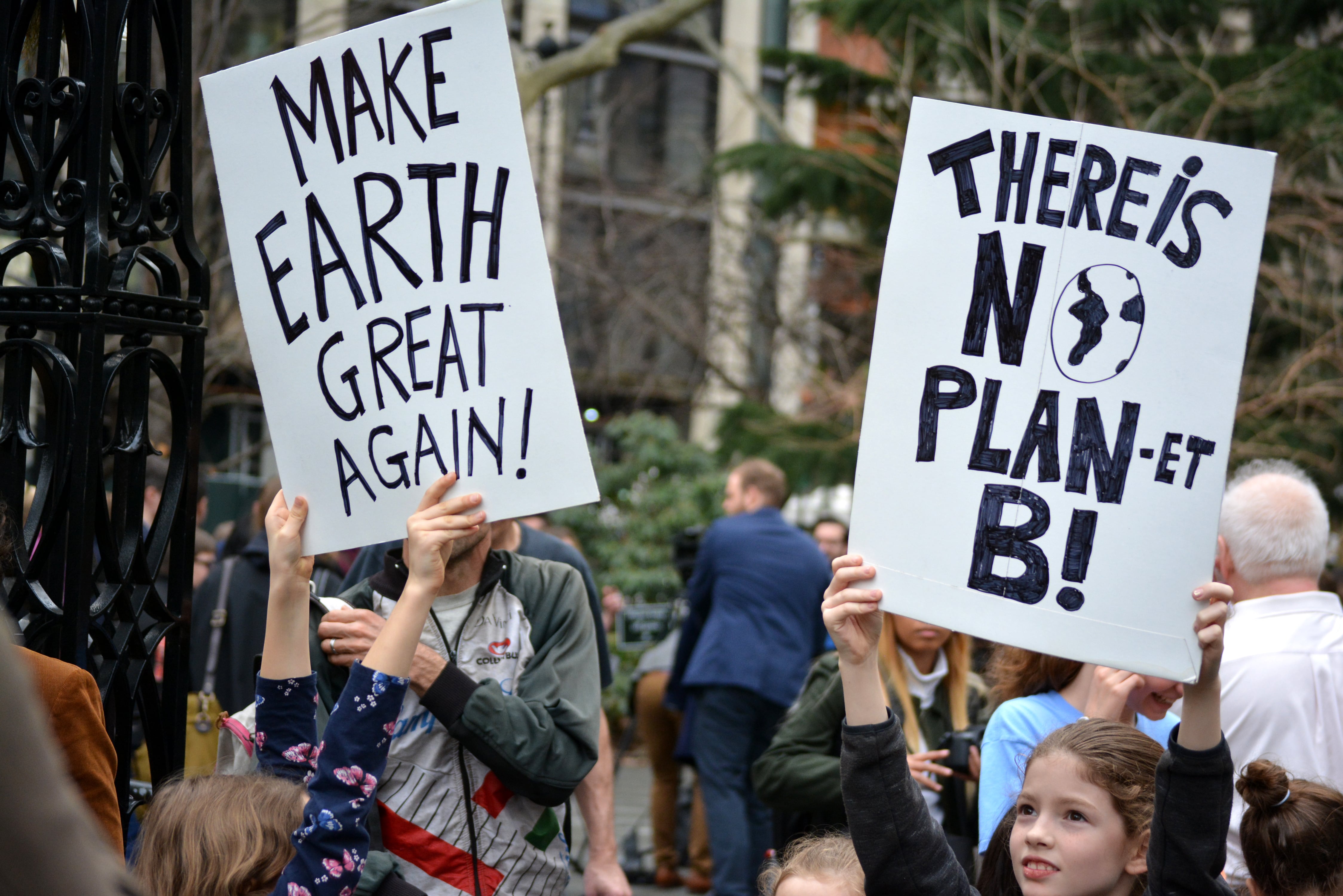 Manifestación contra posturas ambientales de Donald Trump en Manhattan, Nueva York, en 2024. Rótulos aluden a eslóganes de campaña de Trump