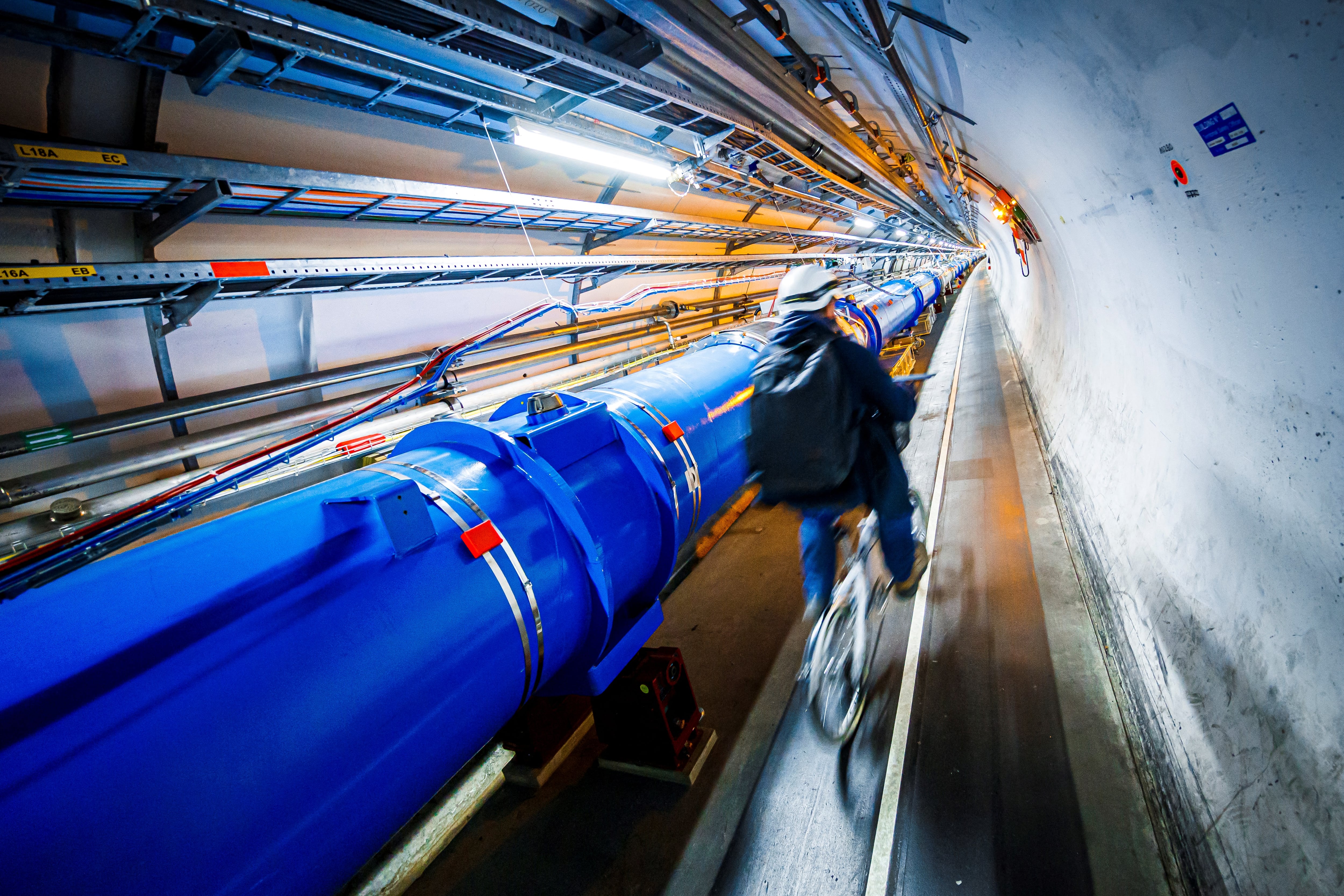 Un investigador recorre en bicicleta la línea de luz del Gran Colisionador de Hadrones (LHC) en un túnel de la Organización Europea para la Investigación Nuclear (CERN), durante obras de mantenimiento en febrero de 2020 en Echenevex, Francia, cerca de Ginebra. Fotografía: