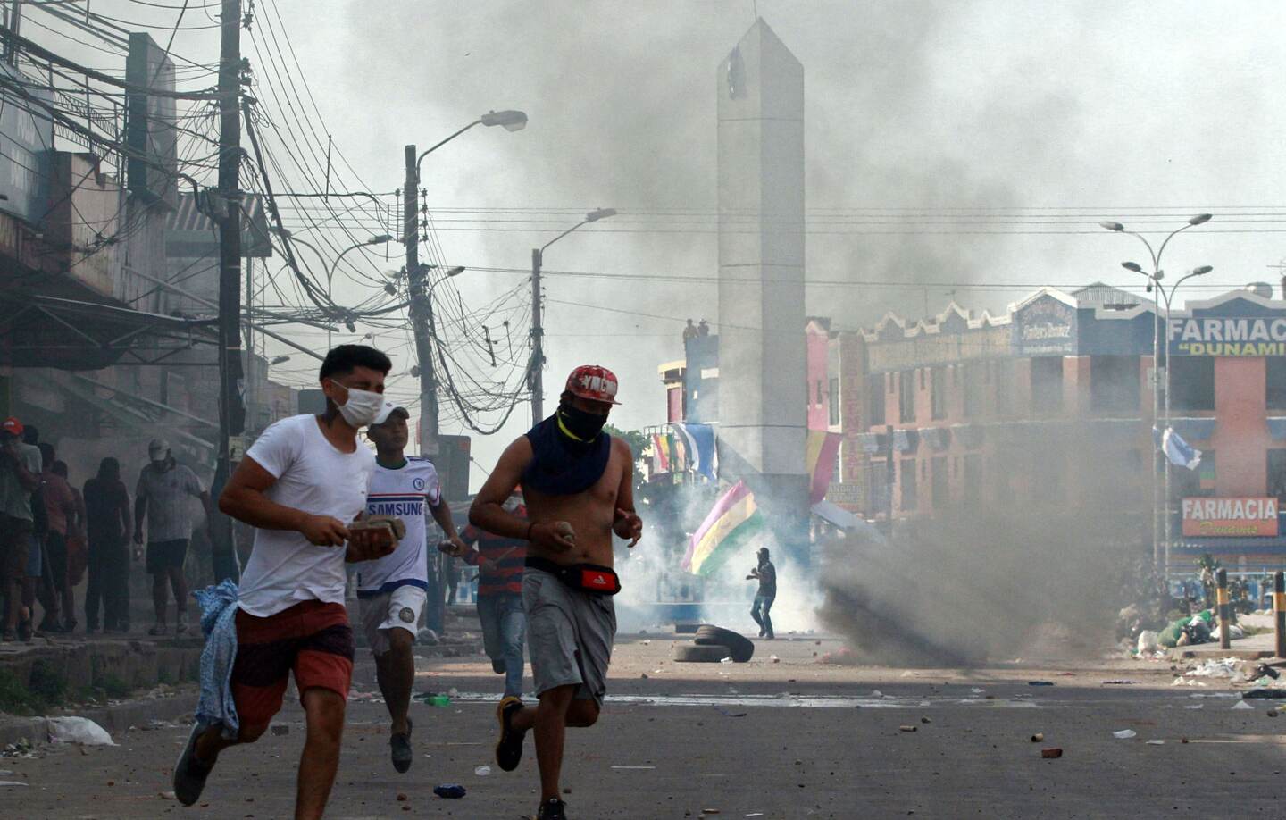Supporters of Bolivian opposition candidate Carlos Mesa and of President Evo Morales clash during a demonstration over disputed poll results, in Santa Cruz, Bolivia, on October 23, 2019. - Bolivia's opposition launched a general strike on Wednesday amid protests and disturbances over disputed election results that pointed to another term for President Evo Morales, who linked the stoppage to a right wing coup. (Photo by DANIEL WALKER / AFP)