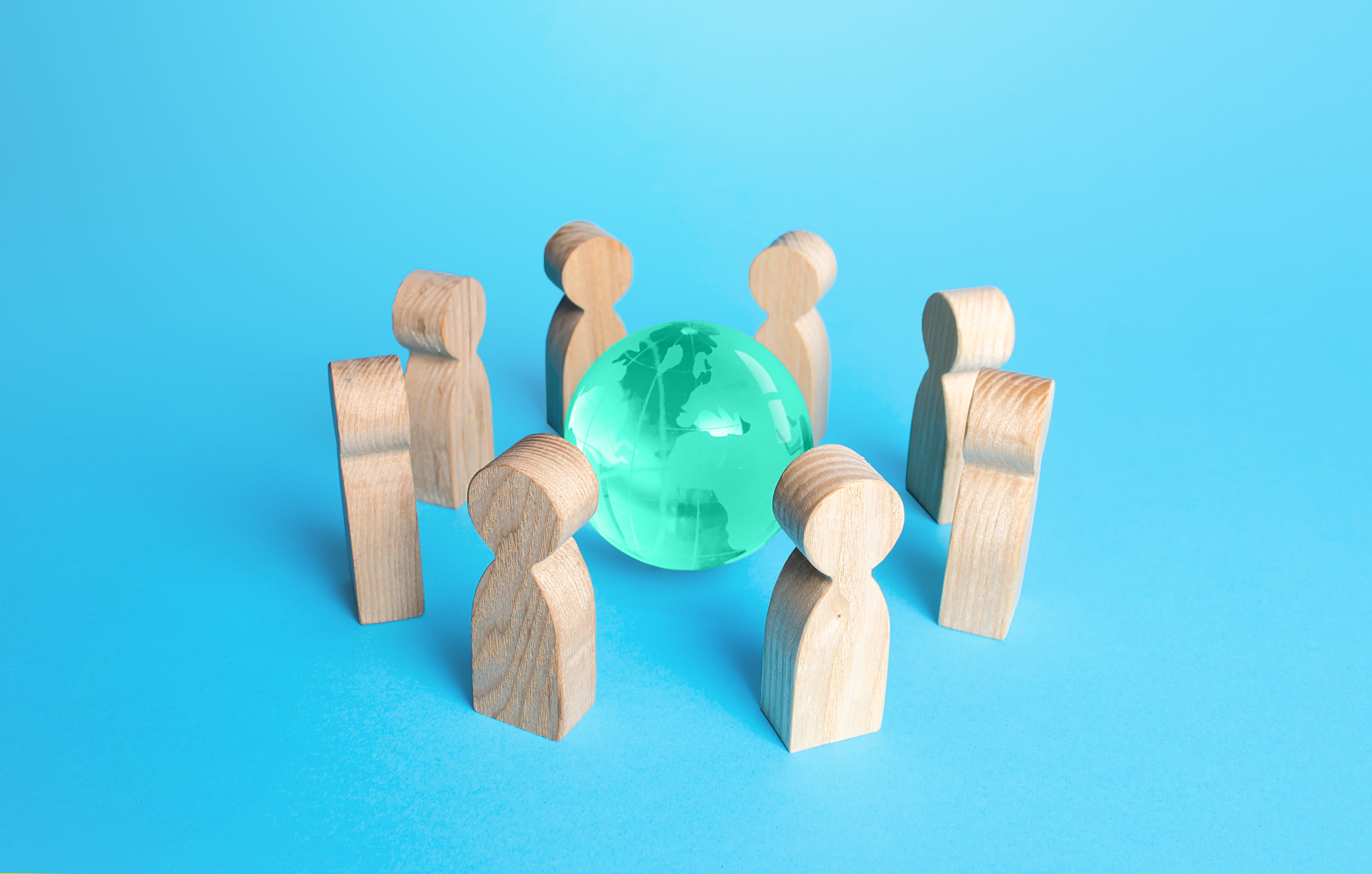 Círculo de personas que rodea el planeta Tierra y el globo terráqueo.