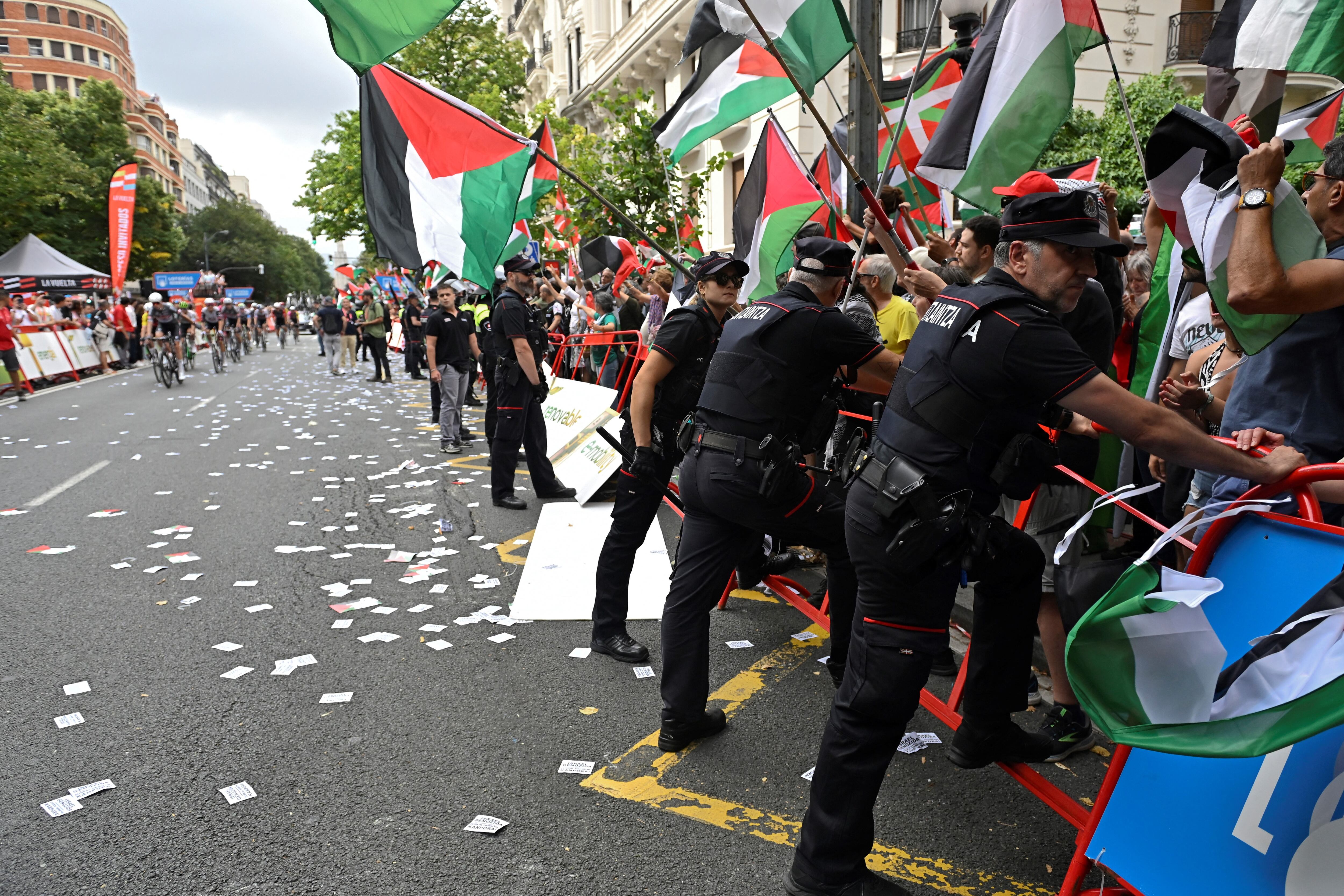 La policía vasca ( conocida como Ertzaintza) tratan de sostener las barreras de los manifestantes propalestinos durante la etapa 11 de la Vuelta a España en Bilbao.