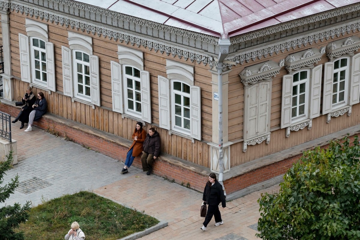 Unas mujeres caminan cerca de una tradicional casa de madera convertida en museo, en la ciudad siberiana de Irkutsk, el 8 de octubre de 2026.