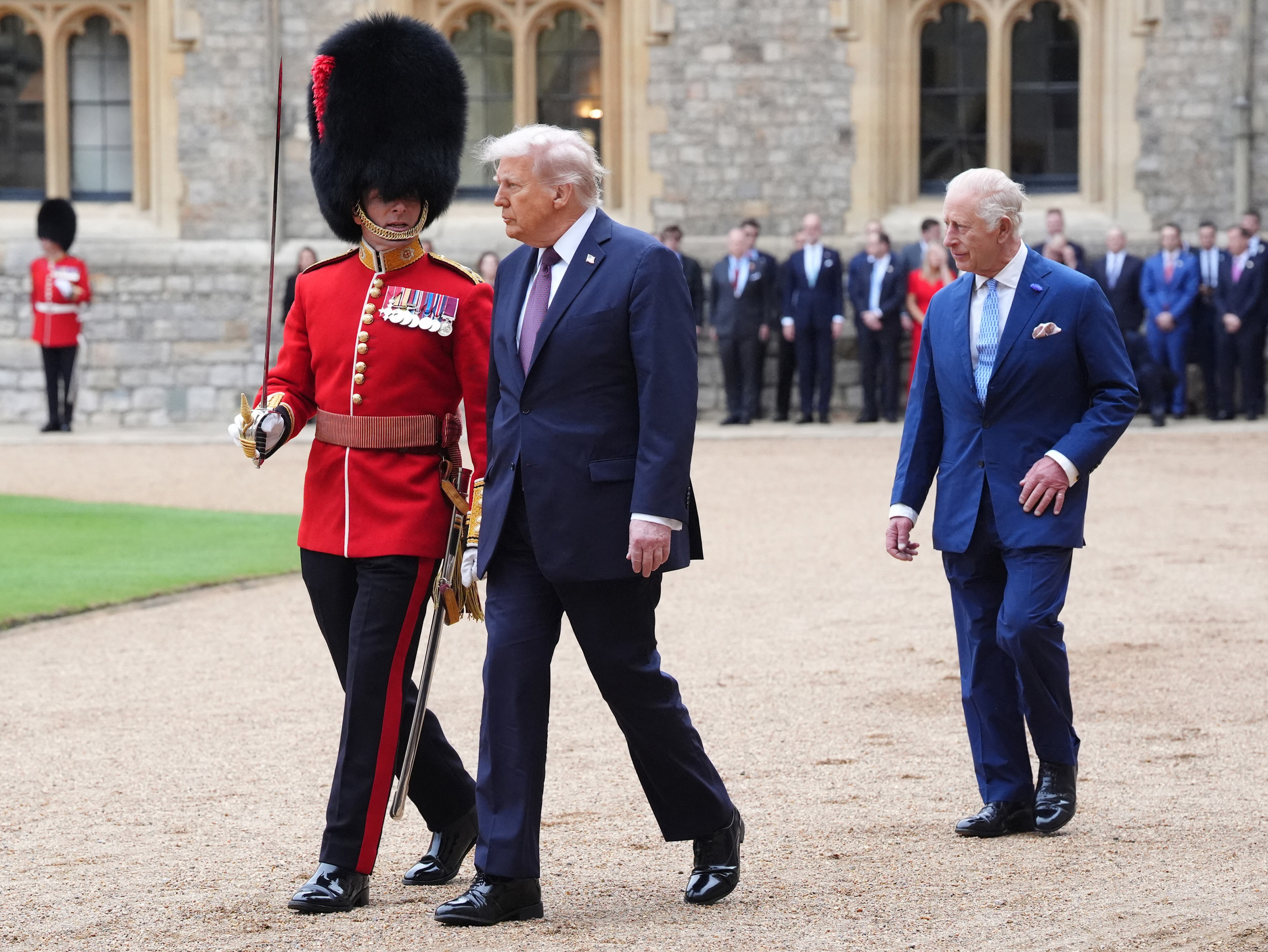 Britain's King Charles III (R) walks with US President Donald Trump to inspect a Guard of Honour during a Ceremonial Welcome in the Quadrangle at Windsor Castle, in Windsor, on September 17, 2025, during the US President's second State Visit. US President Donald Trump arrived in Britain for an unprecedented second State Visit, with the UK government rolling out a royal red carpet welcome to win over the mercurial leader. (Photo by Jonathan Brady / POOL / AFP)