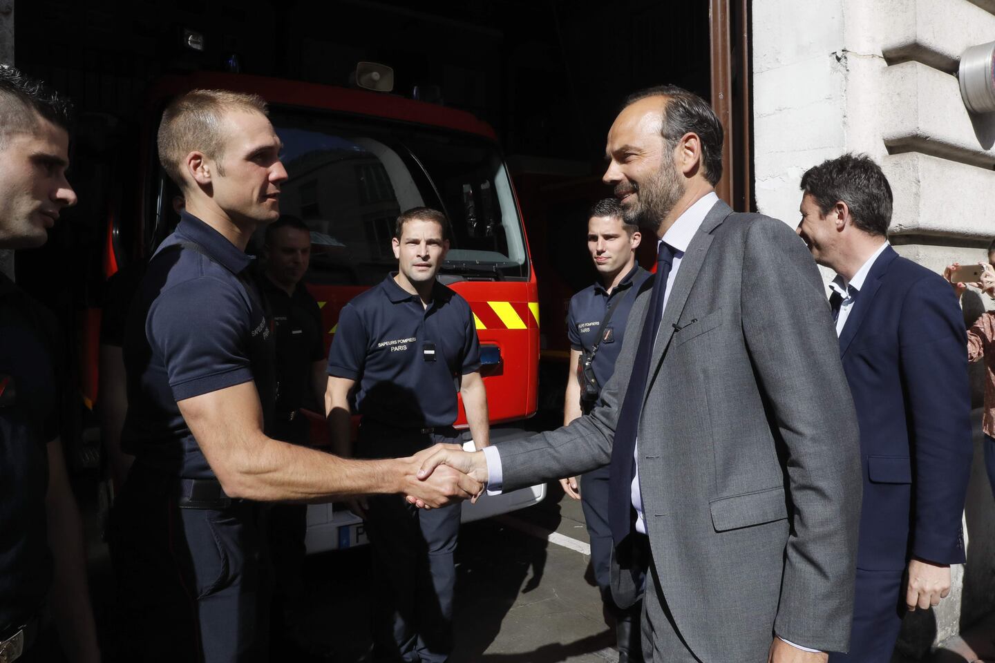 El primer ministro francés Edouard Philippe estrecha la mano de un bombero mientras hace campaña en apoyo del candidato del partido de la República en Marche (REM),Benjamin Griveaux, en París.