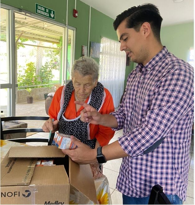 Un hombre joven le muestra productos a una adulta mayor.