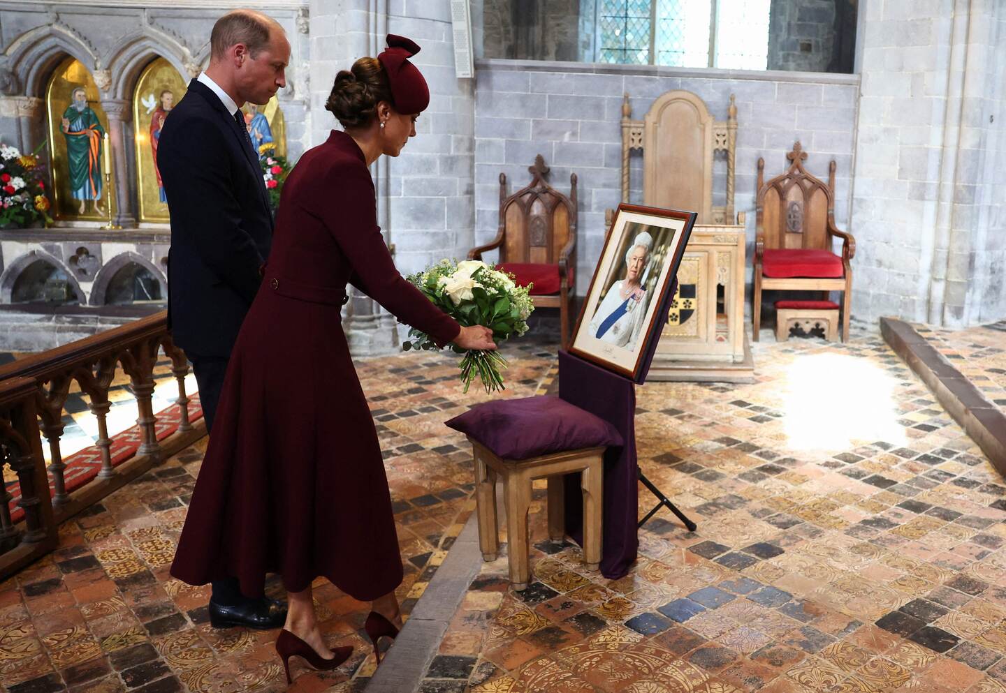 Britain's Prince William, Prince of Wales and Britain's Catherine, Princess of Wales lay flowers during a visit St David's Cathedral in south-west Wales on September 8, 2023, to commemorate the life of Her Late Majesty Queen Elizabeth II on the first anniversary of her passing. (Photo by TOBY MELVILLE / POOL / AFP)