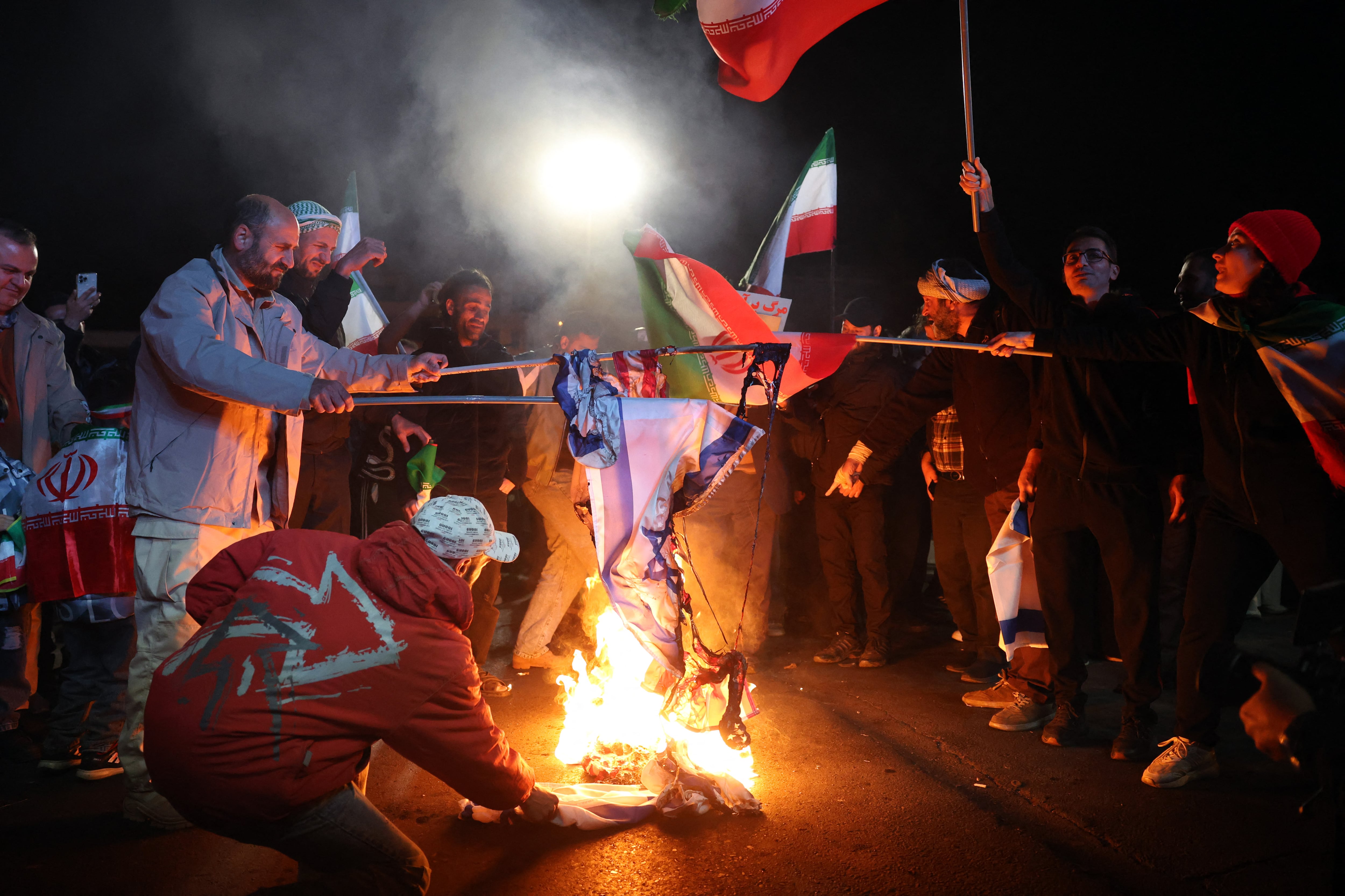 Los iraníes queman banderas estadounidenses e israelíes en señal de protesta tras el anuncio del alto el fuego en la plaza Enqelab, en Teherán, el 8 de abril de 2026.