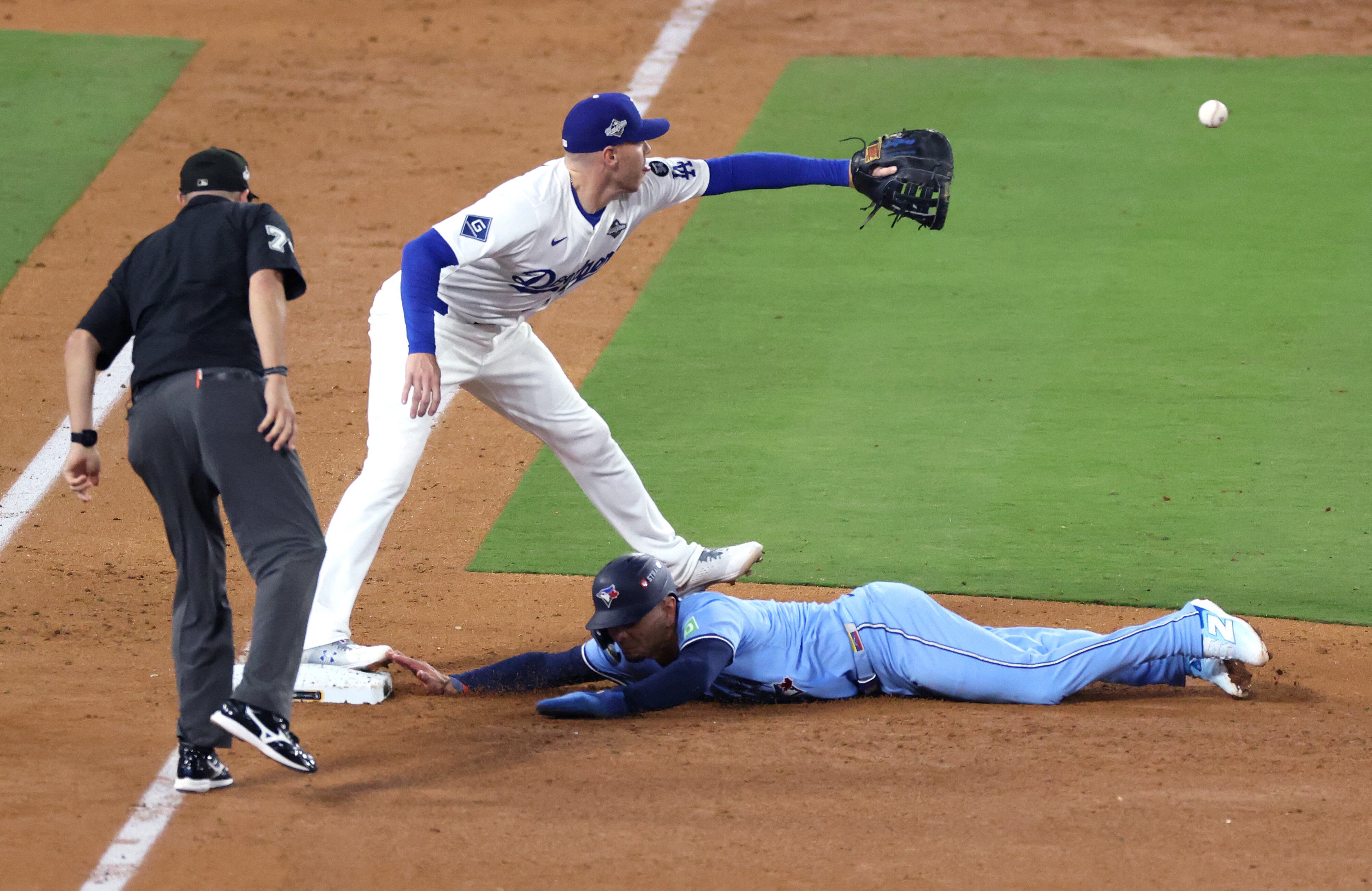 Andrés Giménez de los Azulejos de Toronto se lanza en primera ante la intervención de Freddie Freeman de los Dodgers de Los Ángeles, en el cuarto juego de una pareja Serie Mundial.
