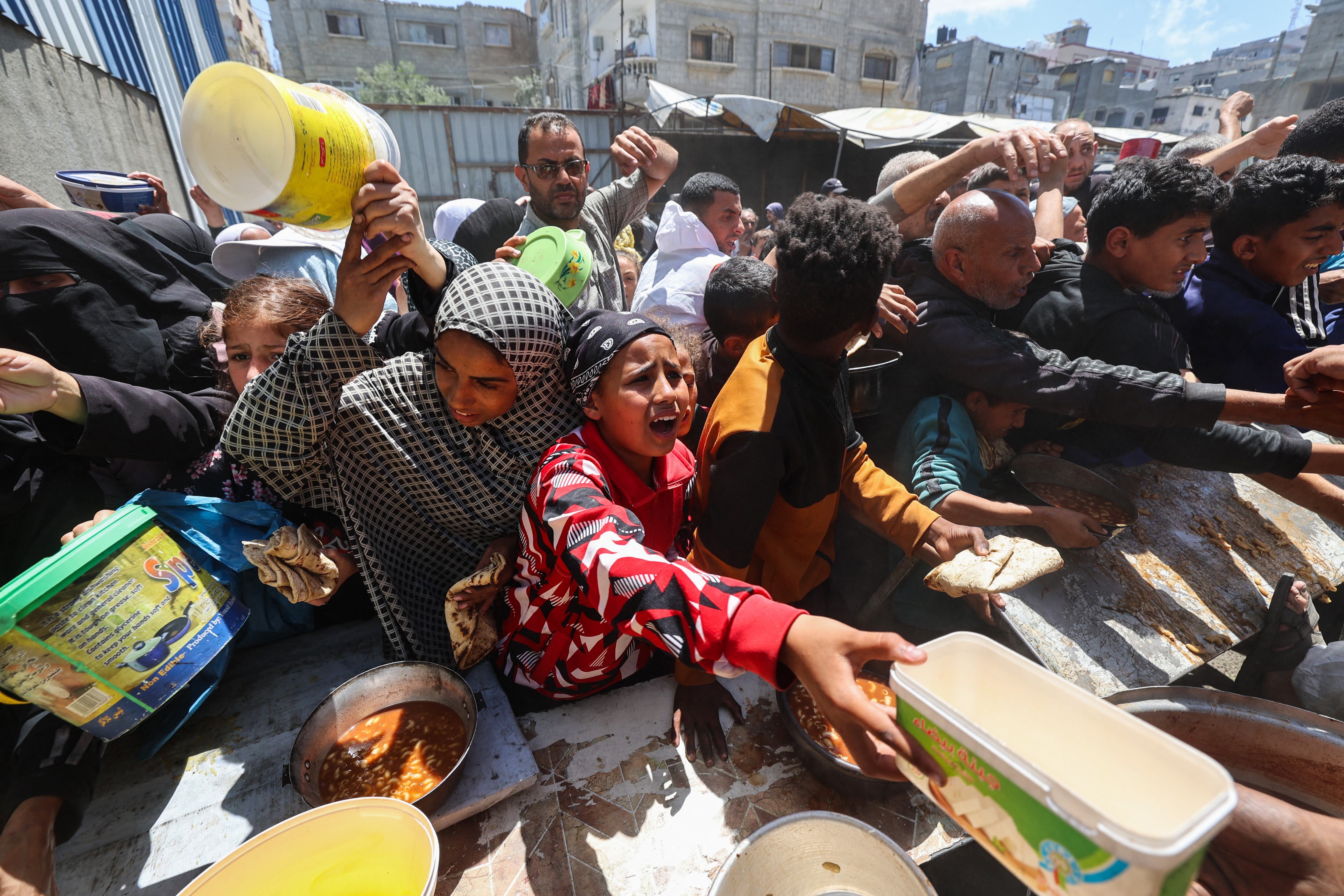 Palestinos en fila para recibir una comida caliente en un comedor social gestionado por el Programa Mundial de Alimentos (PMA) de las Naciones Unidas en el campo de refugiados de Nuseirat, en el centro de la Franja de Gaza, el pasado 26 de abril. Fotografía: