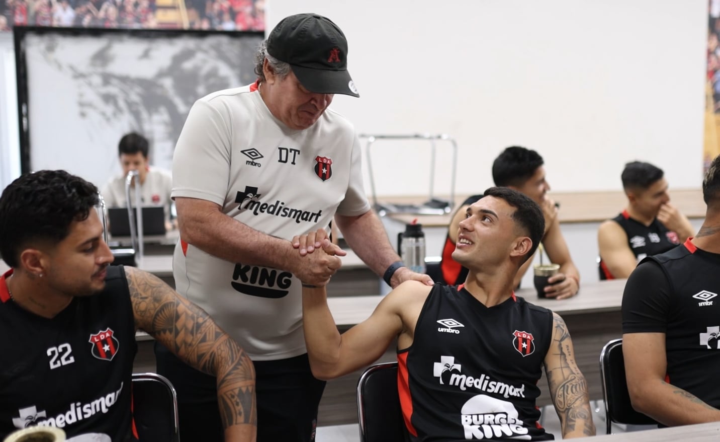 Óscar Ramírez saluda a Malcon Pilone antes de una de las prácticas de Liga Deportiva Alajuelense.