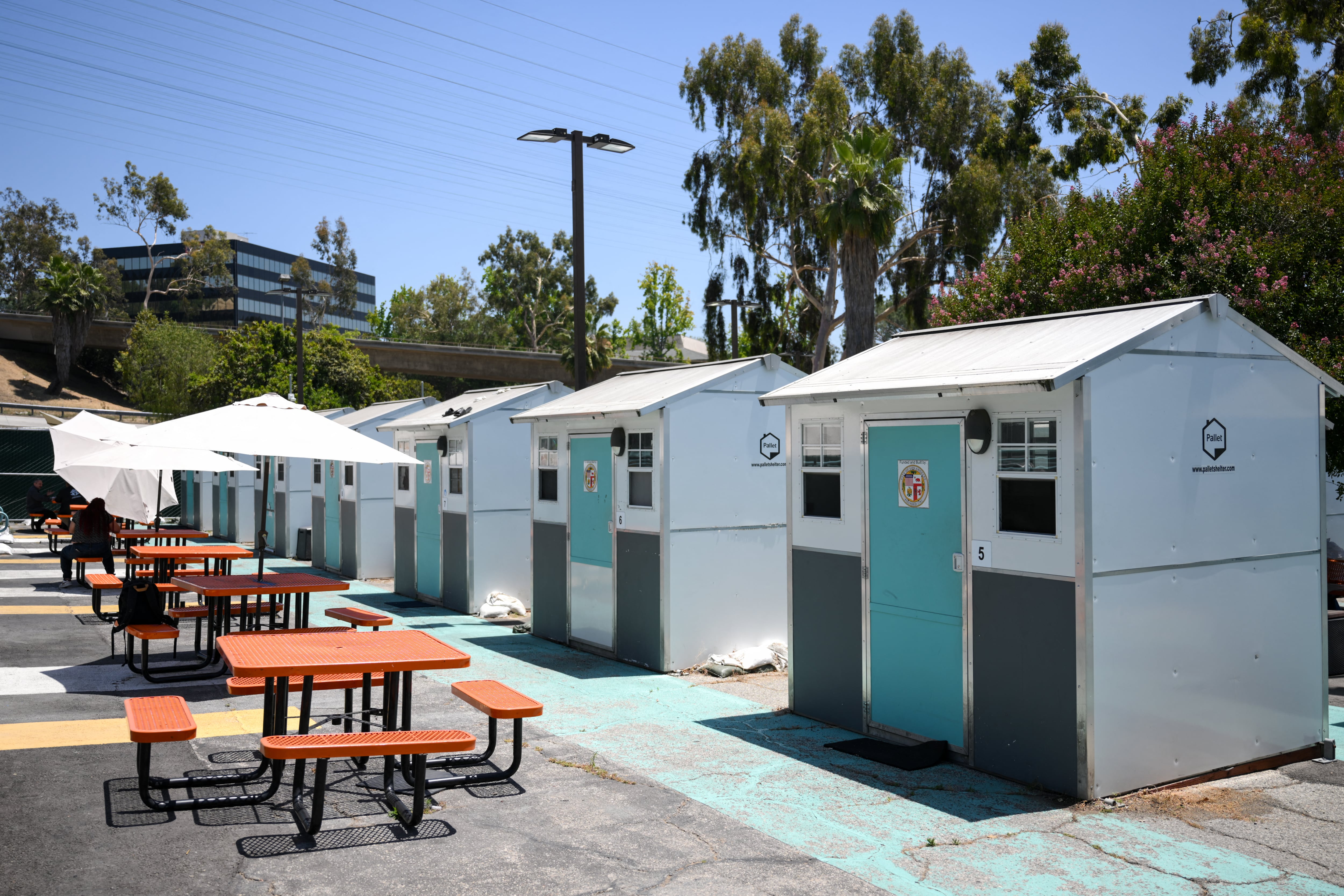 Pallet Shelters stand inside a Tiny Home Village managed by Hope The Mission for interim homeless housing in the Eagle Rock neighborhood of Los Angeles, California on June 1, 2026. Los Angeles, the second-largest US city prepares to host eight World Cup soccer matches this summer, followed by the 2028 Olympics. Infamous for its squalid encampments�located right on the sidewalks or beneath massive highway overpasses�the "City of Angels" has been pulling out all the stops over the past three years to house its homeless population. Democratic Mayor Karen Bass has made this a top priority, ramping up initiatives to fund thousands of housing spots, whether in hotels or in "tiny homes" (Photo by Patrick T. Fallon / AFP)