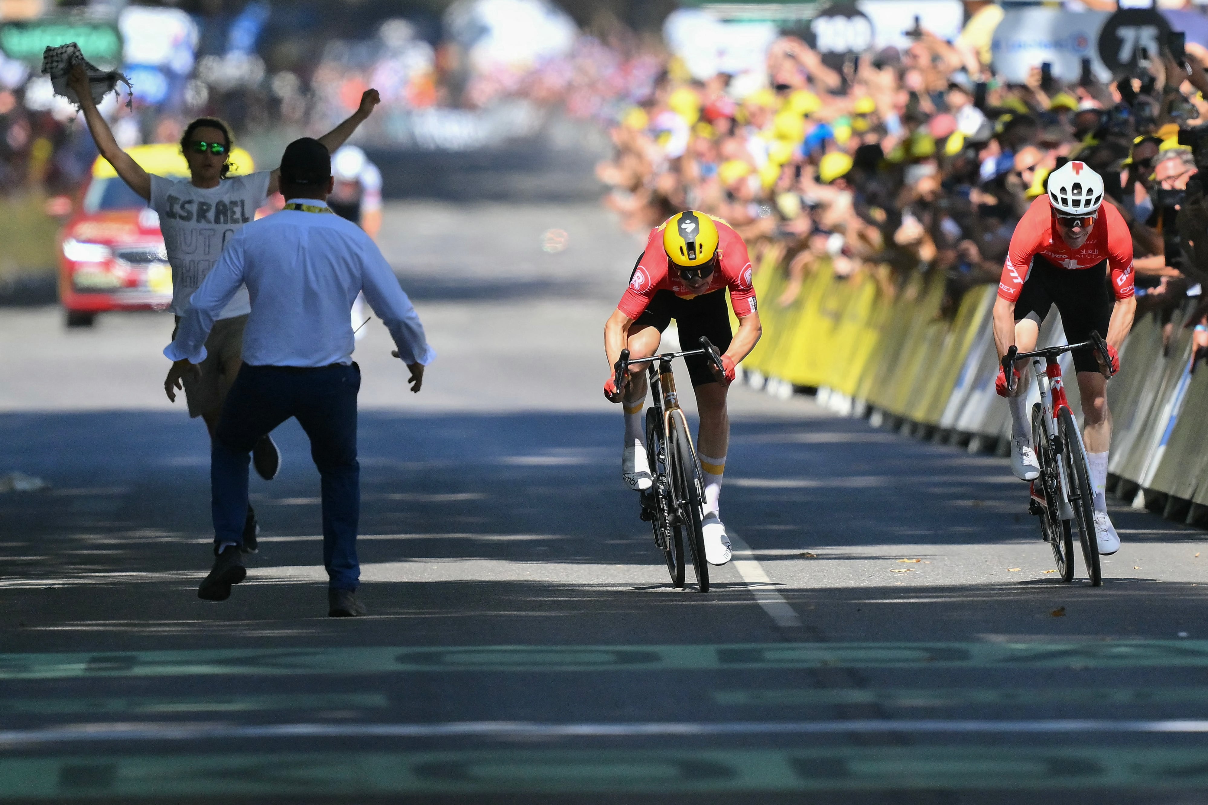 Un miembro de la seguridad del Tour interviene mientras el noruego Jonas Abrahamsen (centro) le gana el sprint al suizo Mauro Schmid, al final de la etapa 11 del Tour de Francia.
