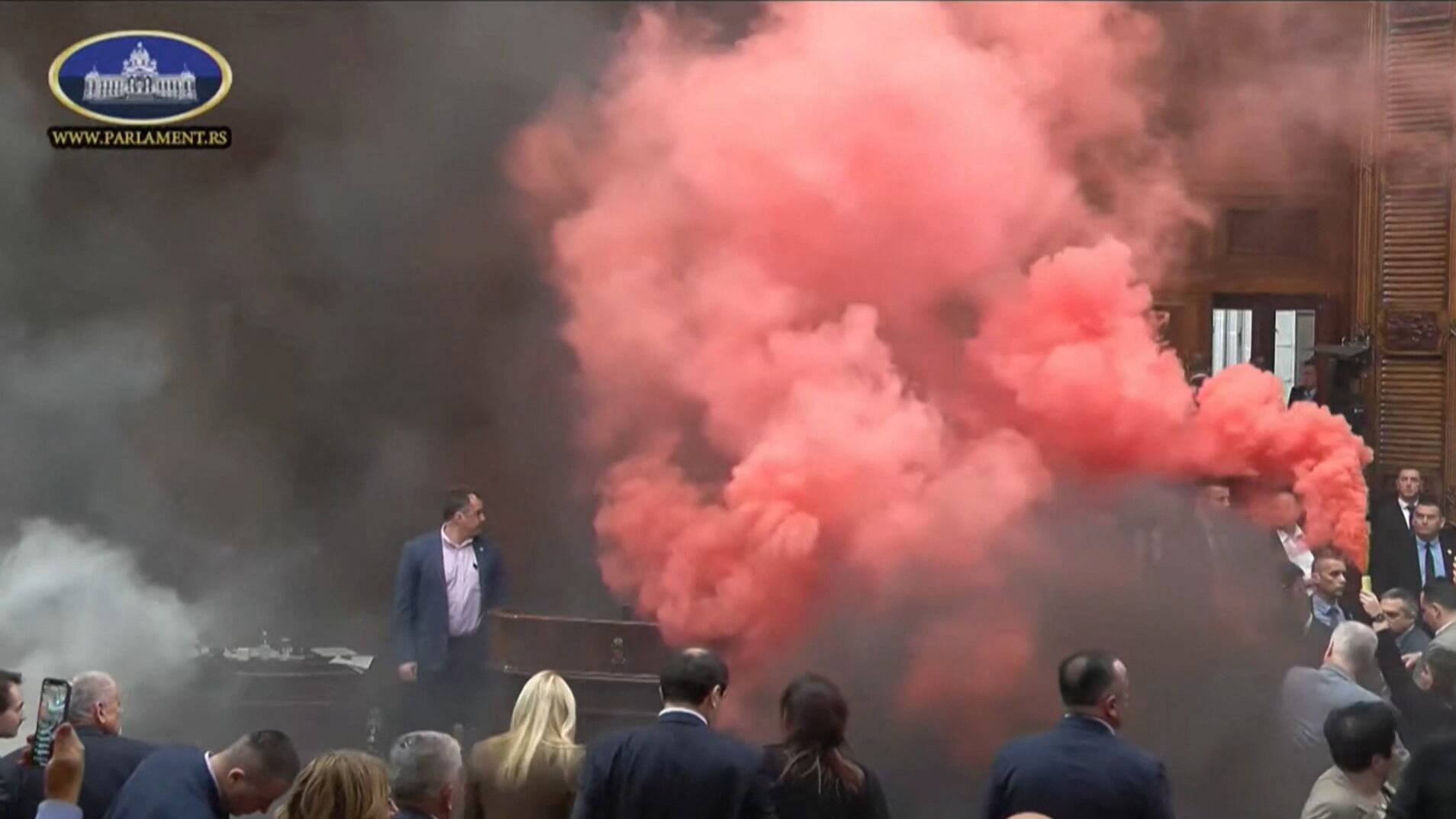This frame grab from handout video footage taken and released by the National Assembly of the Republic of Serbia in Belgrade on March 4, 2025 shows Serbian opposition lawmakers lighting flares and discharging suspected tear gas during the openin