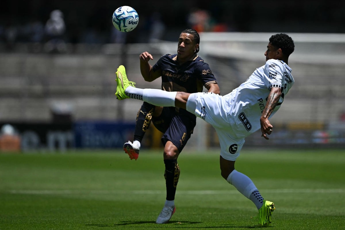 Paulo Víctor y Adalberto Carrasquilla disputan el balón durante el partido entre Pumas y Querétaro, en la Liga MX, en el Estadio Olímpico Universitario.
