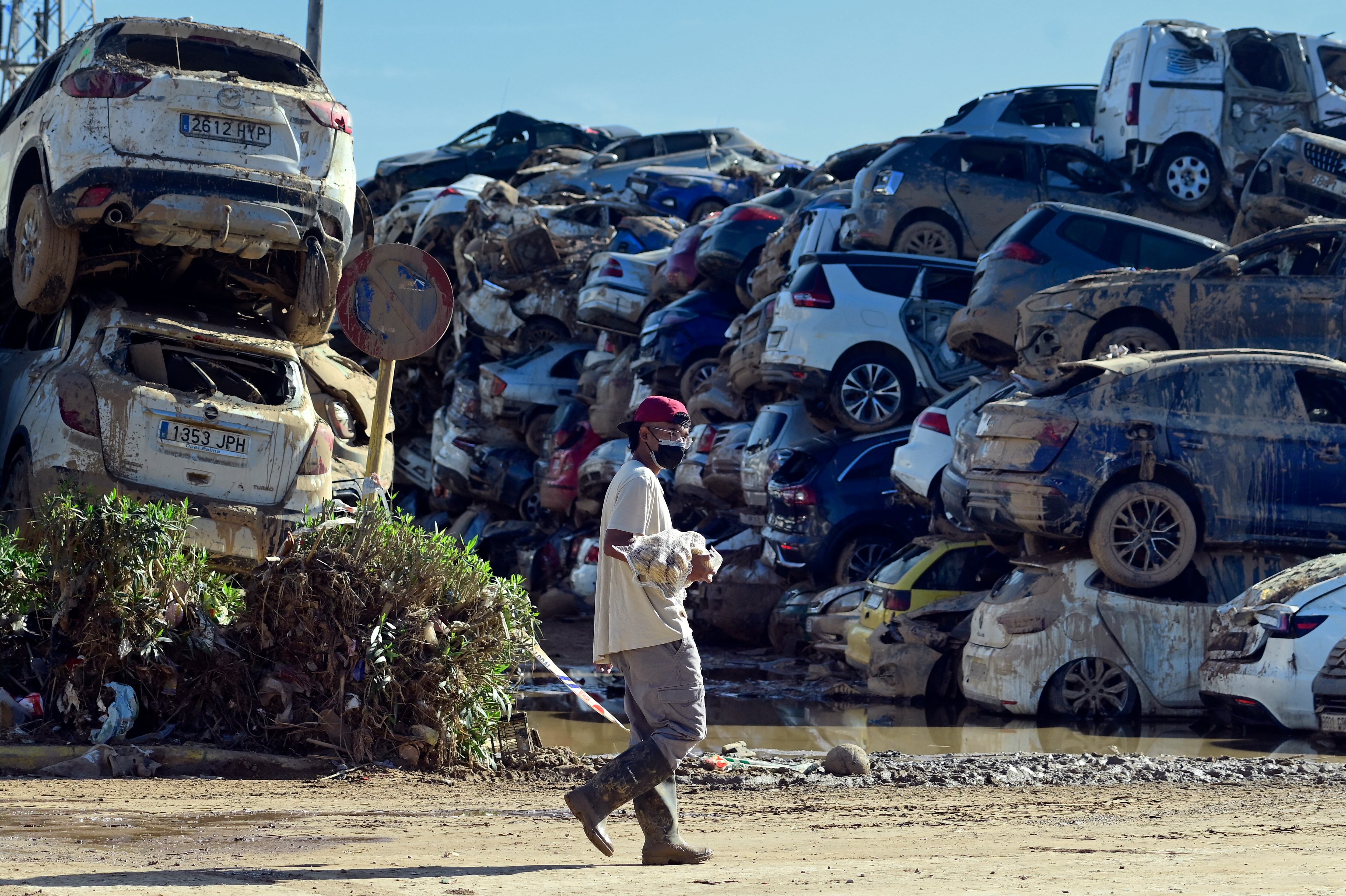 Una persona camina junto a montones de coches dañados por las inundaciones en Paiporta, en la región de Valencia, este de España. La tragedia del 29 de octubre dejó 222 fallecidos y decenas de desaparecidos en Valencia.