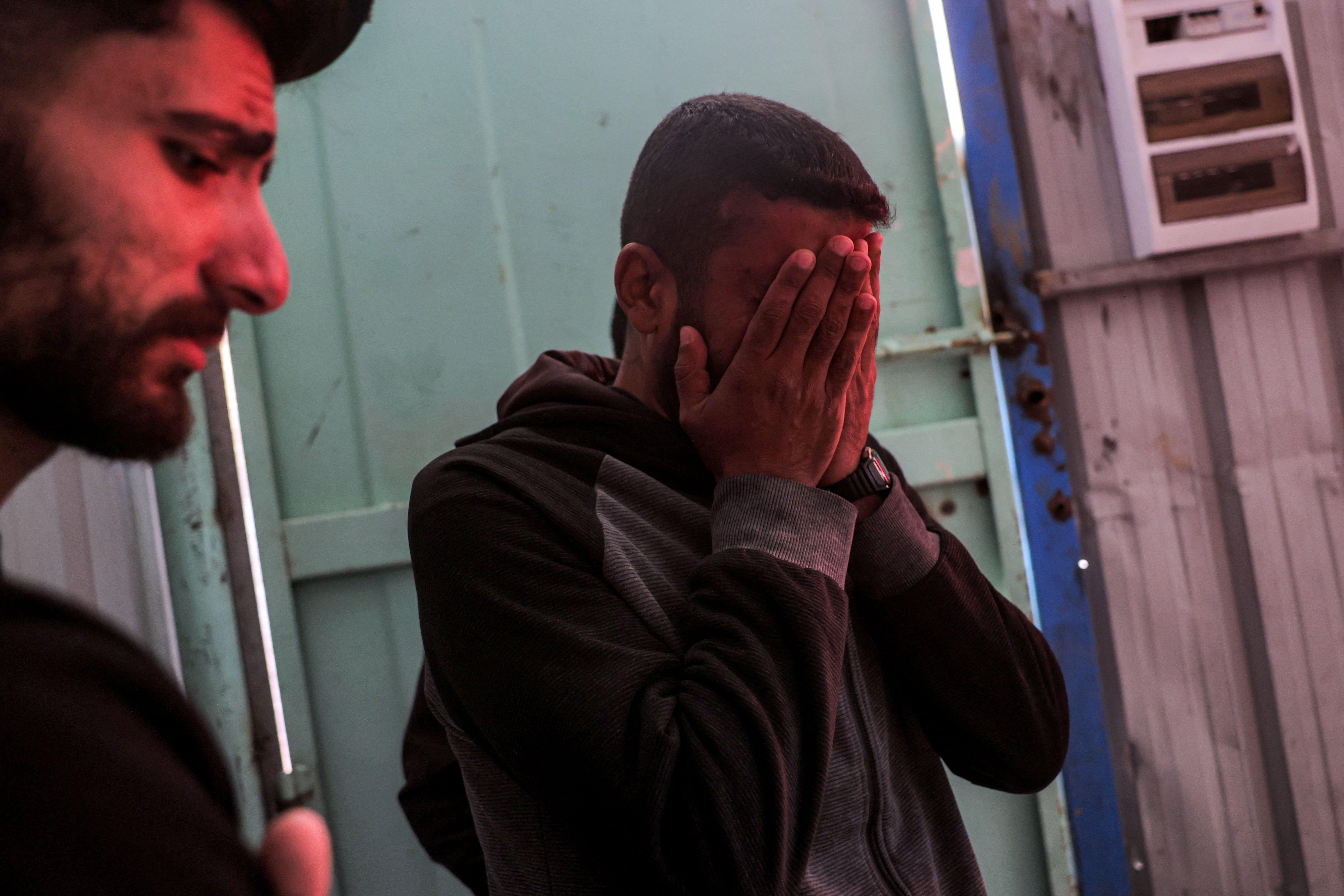 EDITORS NOTE: Graphic content / A man reacts as he stands before the bodies of victims killed by Israeli bombardment in Jabalia lie at a morgue at the Indonesian Hospital in Beit Lahia in the northern Gaza Strip on April 18, 2025. Gaza's civil defence agency said on April 18 that 15 people, including 10 from the same family, had been killed in two overnight strikes as Israeli pressed its unrelenting military offensive in the Palestinian territory. Israel had resumed its intense military offensive in the Palestinian territory after a ceasefire deal that came into effect on January 19 fell apart two months later over differences regarding its next phase. (Photo by BASHAR TALEB / AFP)
