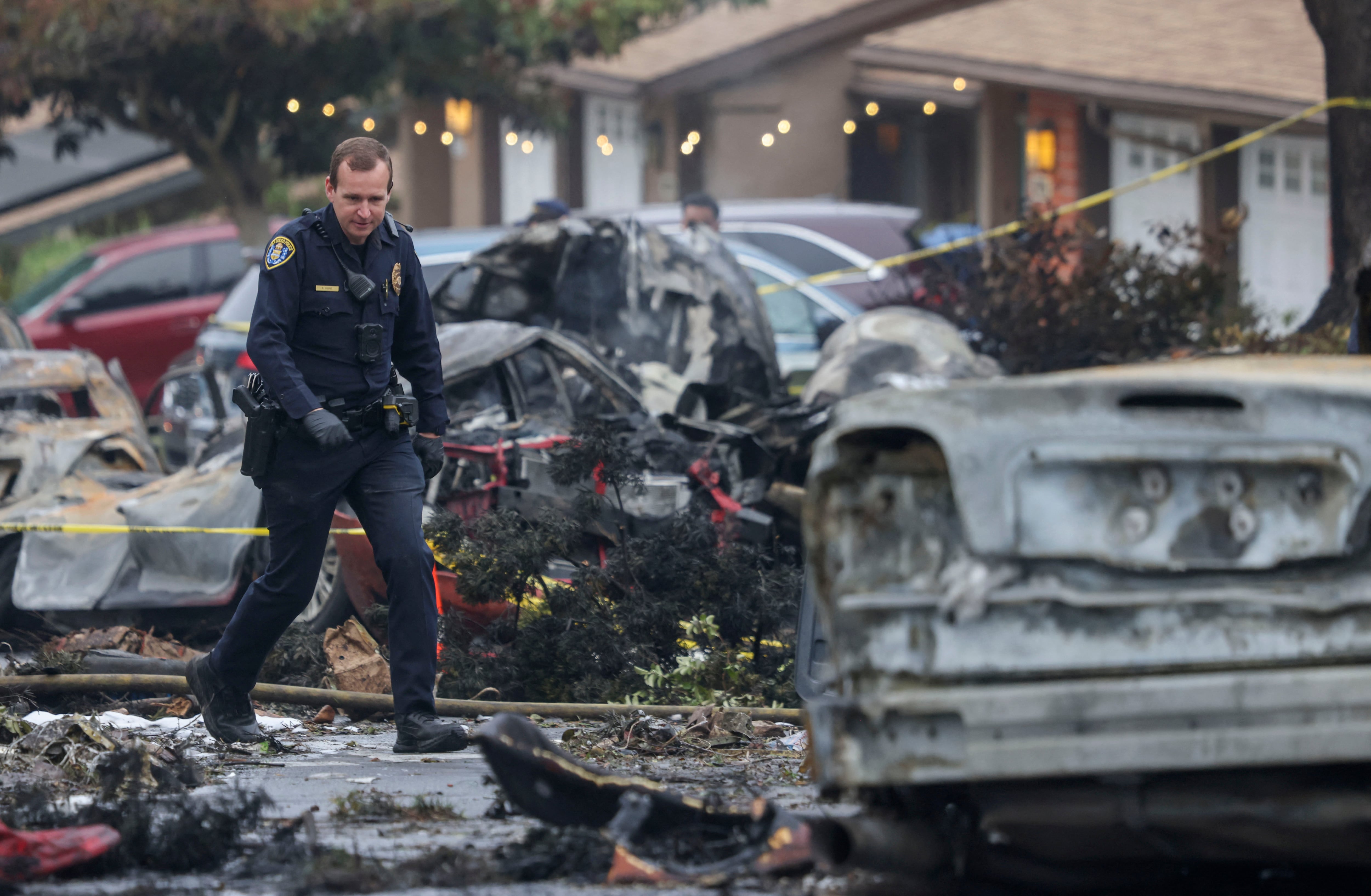 Investigators look through the site where a small plane crashed into a San Diego, California, residential street on May 22, 2025. The Federal Aviation Authority said a Cessna 550 crashed at around 3:45 am local time. The neighborhood is close to the Montgomery-Gibbs Executive Airport. The crash left a "gigantic debris field" and damaged some 15 homes and parked cars, ABC News quoted the San Diego assistant fire chief as saying. (Photo by Sandy Huffaker / AFP)