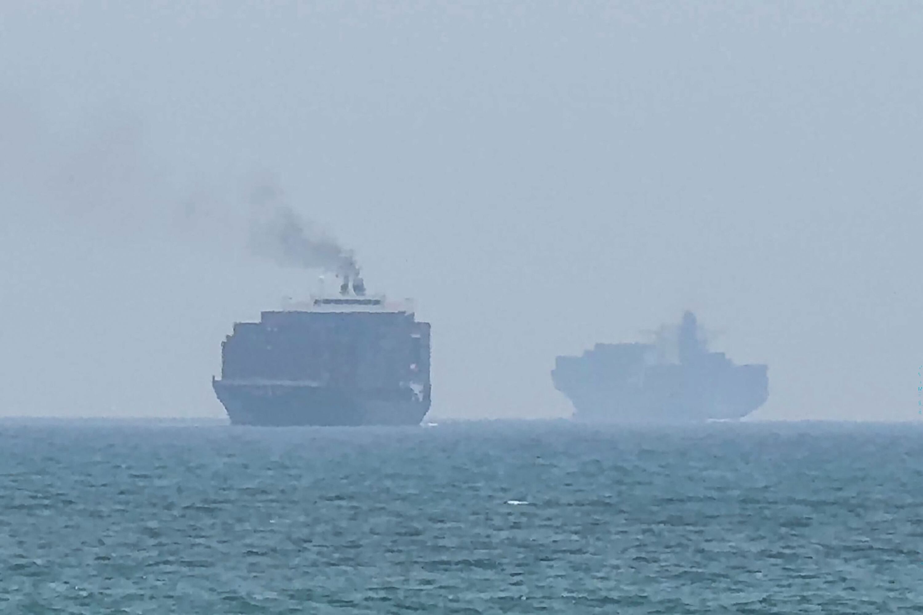 Esta captura de pantalla tomada de un video de AFPTV del 12 de julio en Irán muestra buques de carga anclados cerca del Estrecho de Ormuz, frente a la costa oriental de los Emiratos Árabes Unidos en Khor Fakkan.