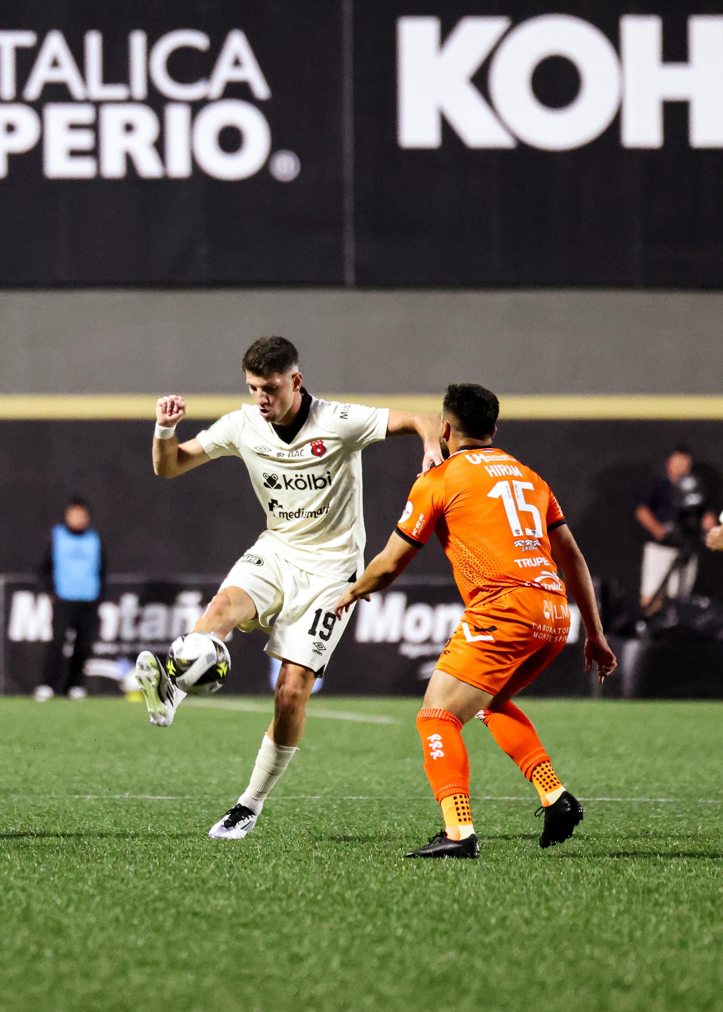 Alberto Toril le gana un duelo a Hiram Muñoz en el partido entre Puntarenas FC y Liga Deportiva Alajuelense.