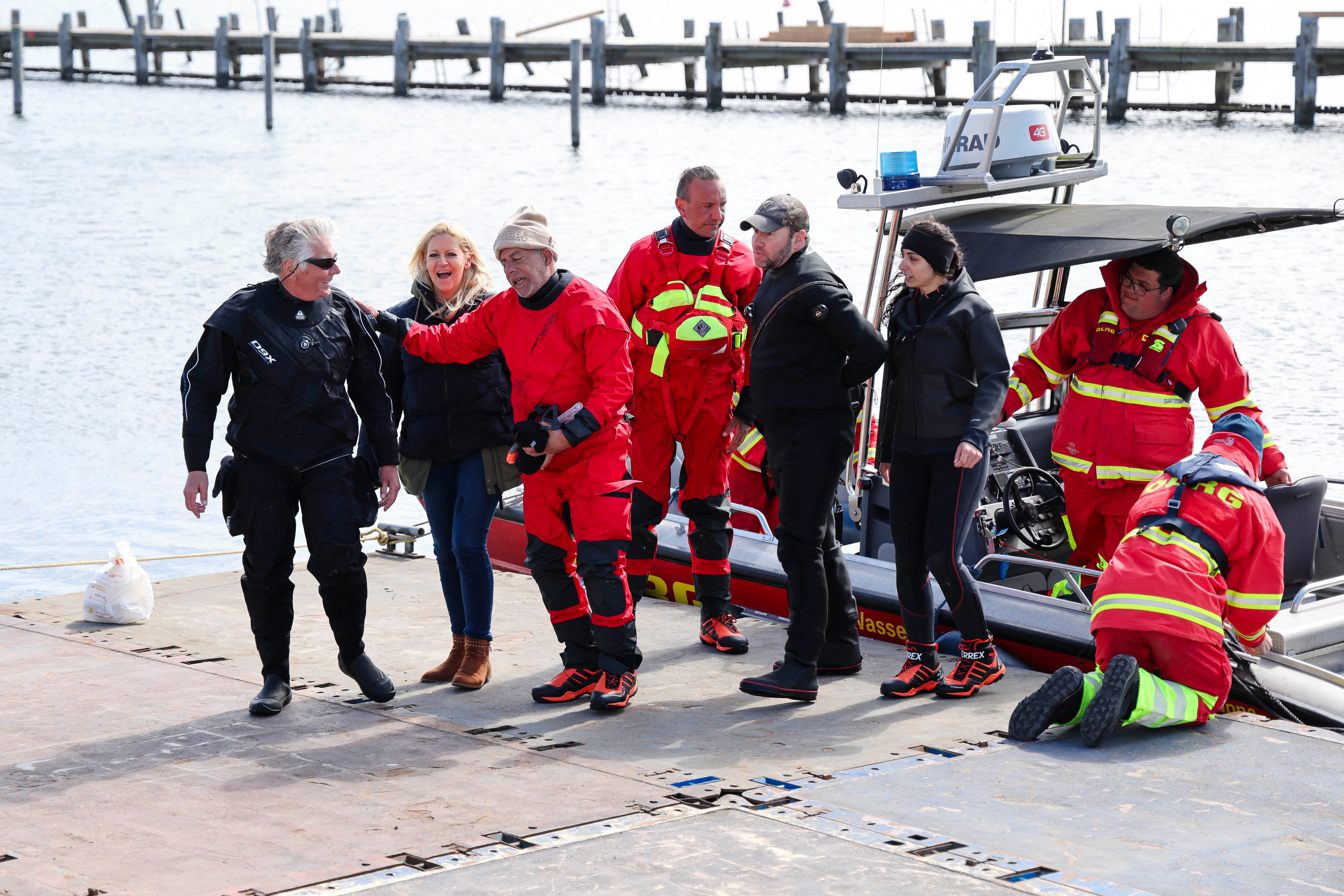 Jeffrey Foster (izq.) y Michael Patica (segundo por la derecha) desembarcan de su barco con los miembros del equipo de rescate estadounidense mientras continúan los esfuerzos para salvar a una ballena jorobada en la costa del mar Báltico, cerca de la isla de Poel, cerca de Wismar, en el norte de Alemania, el 24 de abril de 2026. Un intento de rescate privado para la ballena aún continúa. La odisea de la ballena jorobada de 13,5 metros (44 pies) comenzó a finales de marzo de 2026 cuando fue avistada atascada en un banco de arena cerca de la ciudad de Lübeck. Logró liberarse por primera vez, pero volvió a quedar atascada más al este, a lo largo de la costa alemana. A principios de abril de 2026, las autoridades dijeron que esperaban que el animal muriera, ya que estaba demasiado debilitado por la odisea para sobrevivir y regresar a su hábitat natural en el Atlántico. La cobertura de la lucha de la ballena por sobrevivir y los esfuerzos para rescatarla han cautivado al público alemán, y algunos medios de comunicación han llamado al animal "Timmy".