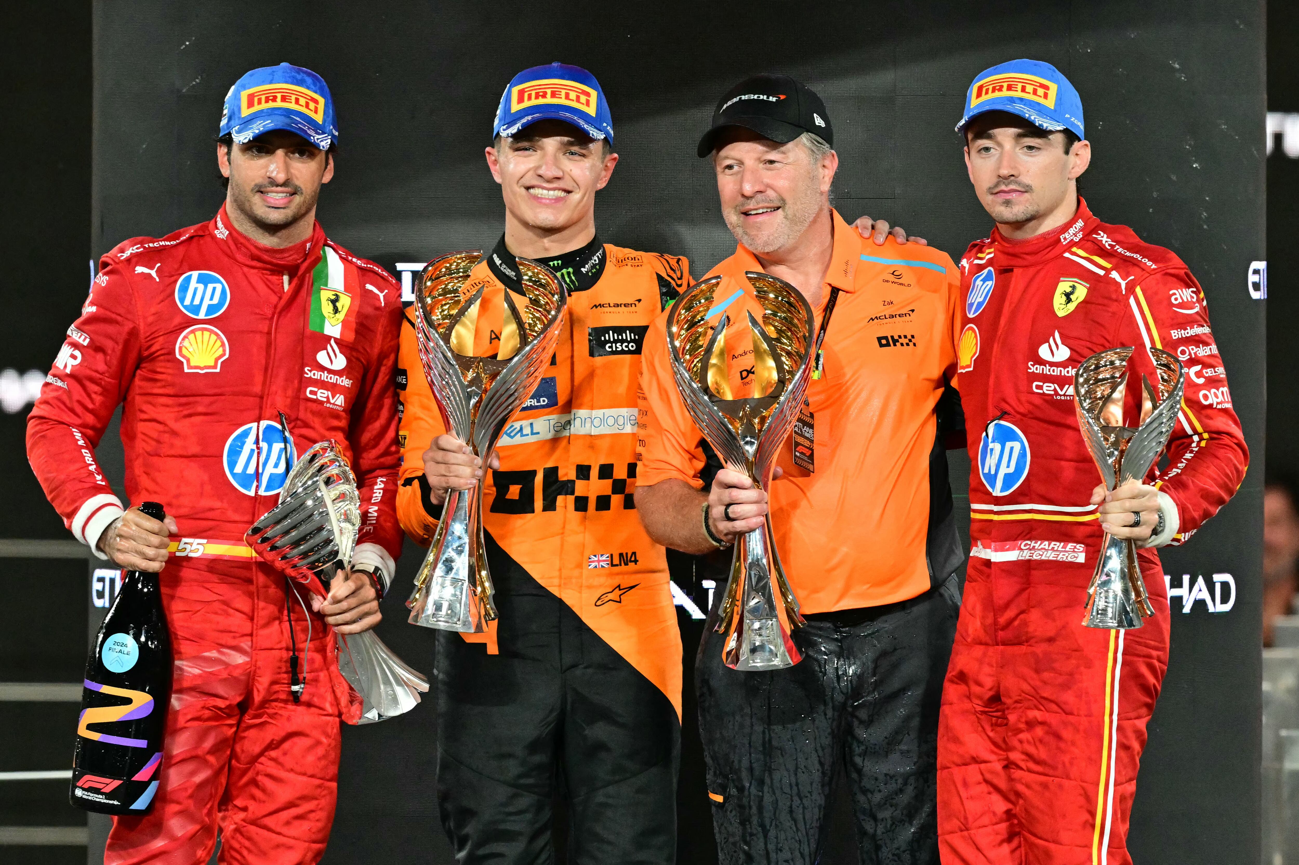 (De izq. a der.) El piloto español de Ferrari Carlos Sainz Jr., el piloto británico de McLaren Lando Norris, el director estadounidense de McLaren Zak Brown y el piloto de Ferrari Charles Leclerc celebran en el podio después del Gran Premio de Fórmula Uno de Abu Dabi.