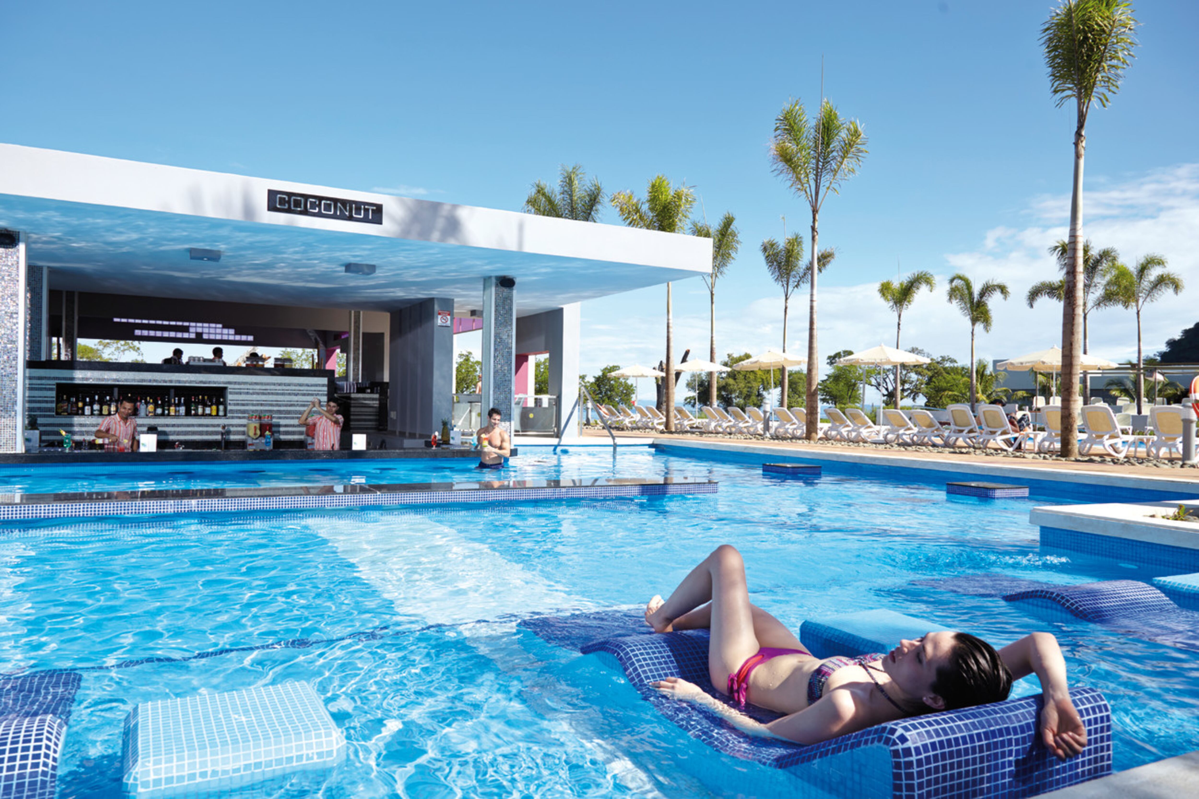 Vacacionista en una piscina en un hotel con sistema todo incluido.