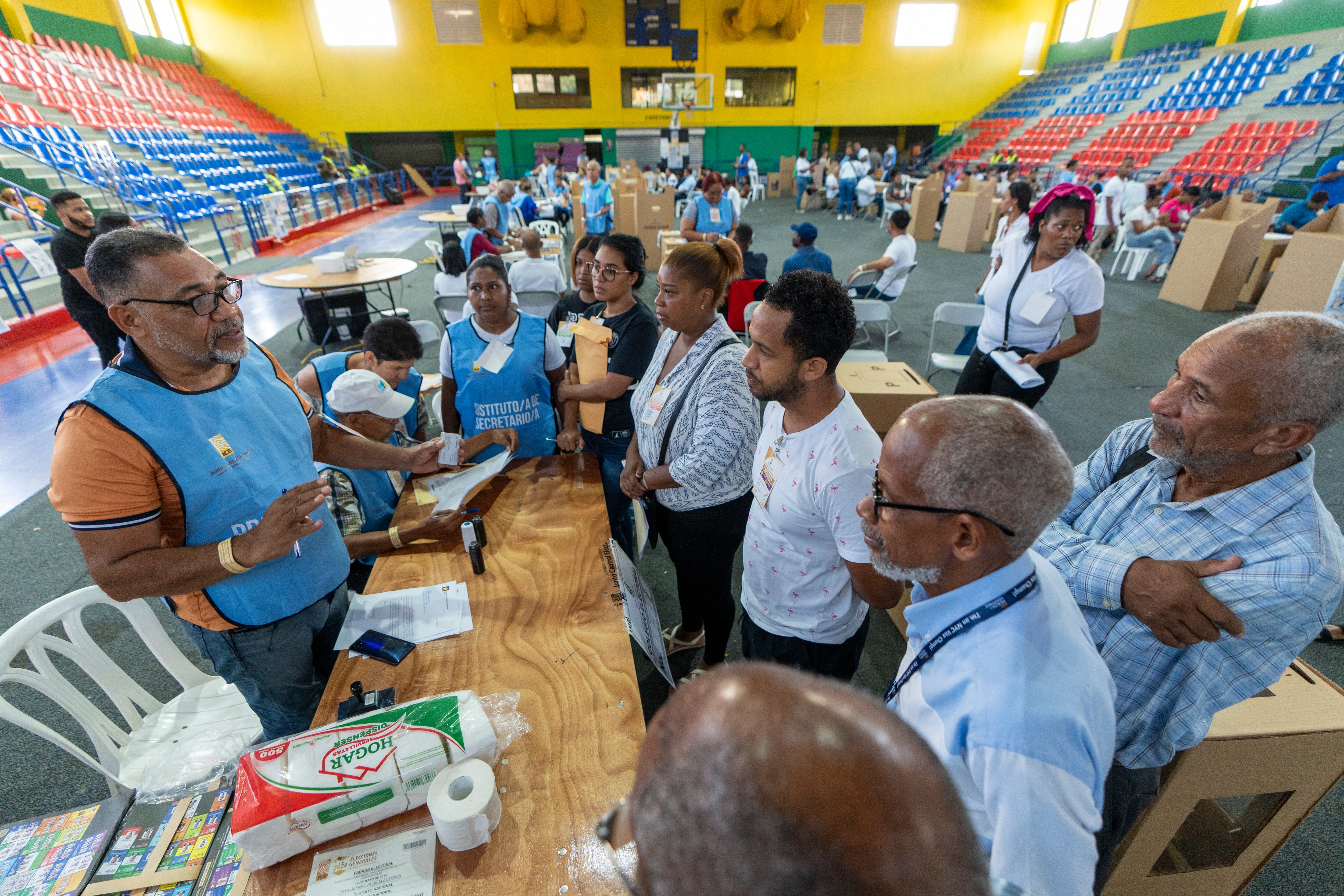 Los funcionarios electorales se preparan para abrir una mesa electoral durante las elecciones generales en Santo Domingo.