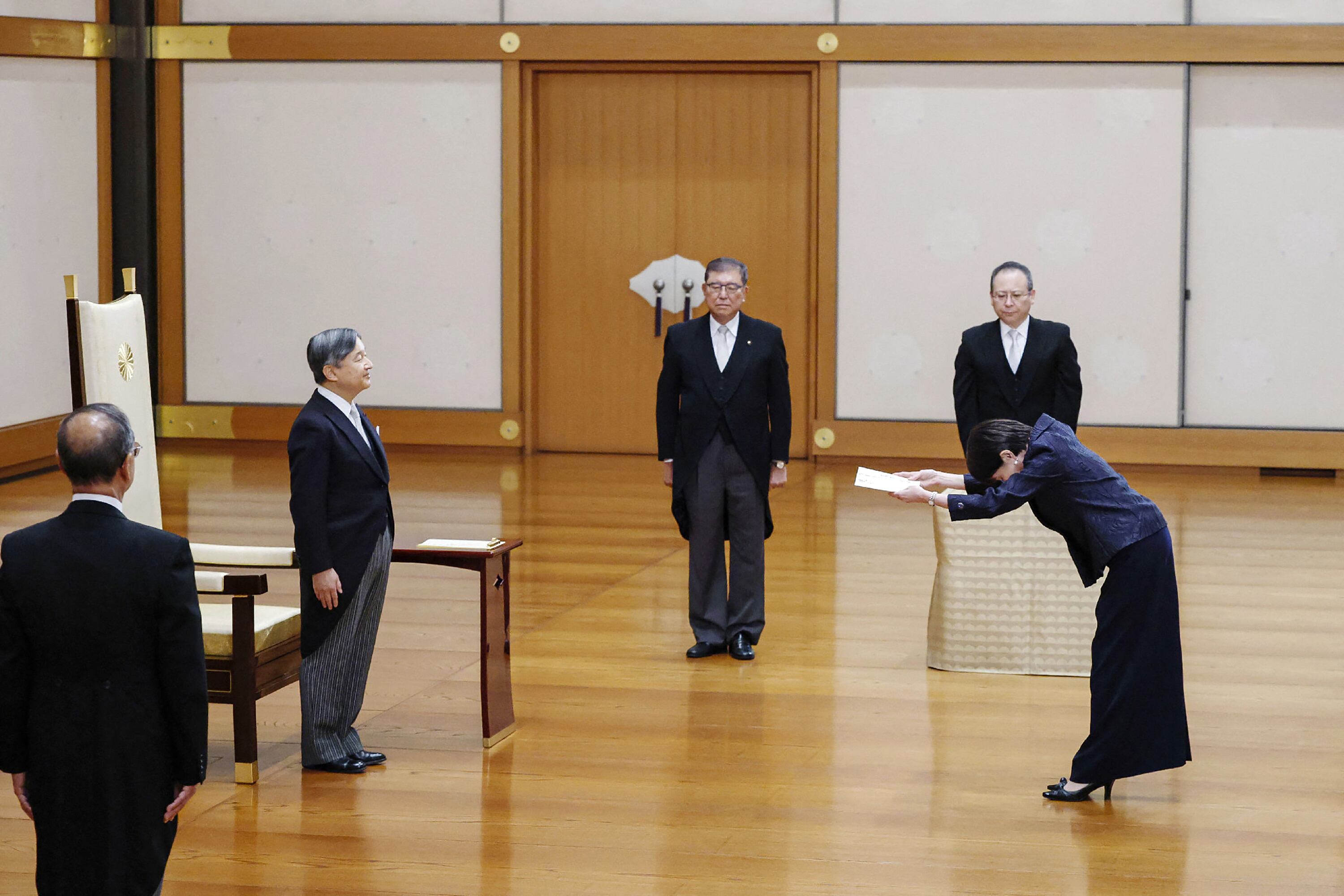 El emperador de Japón, Naruhito (segundo desde la izquierda), se encuentra frente a la nueva primera ministra, Sanae Takaichi (derecha), mientras que el ex primer ministro Shigeru Ishiba (centro) observa durante la ceremonia de investidura de Takaichi en el Palacio Imperial de Tokio, esre 21 de octubre. Fotografía: