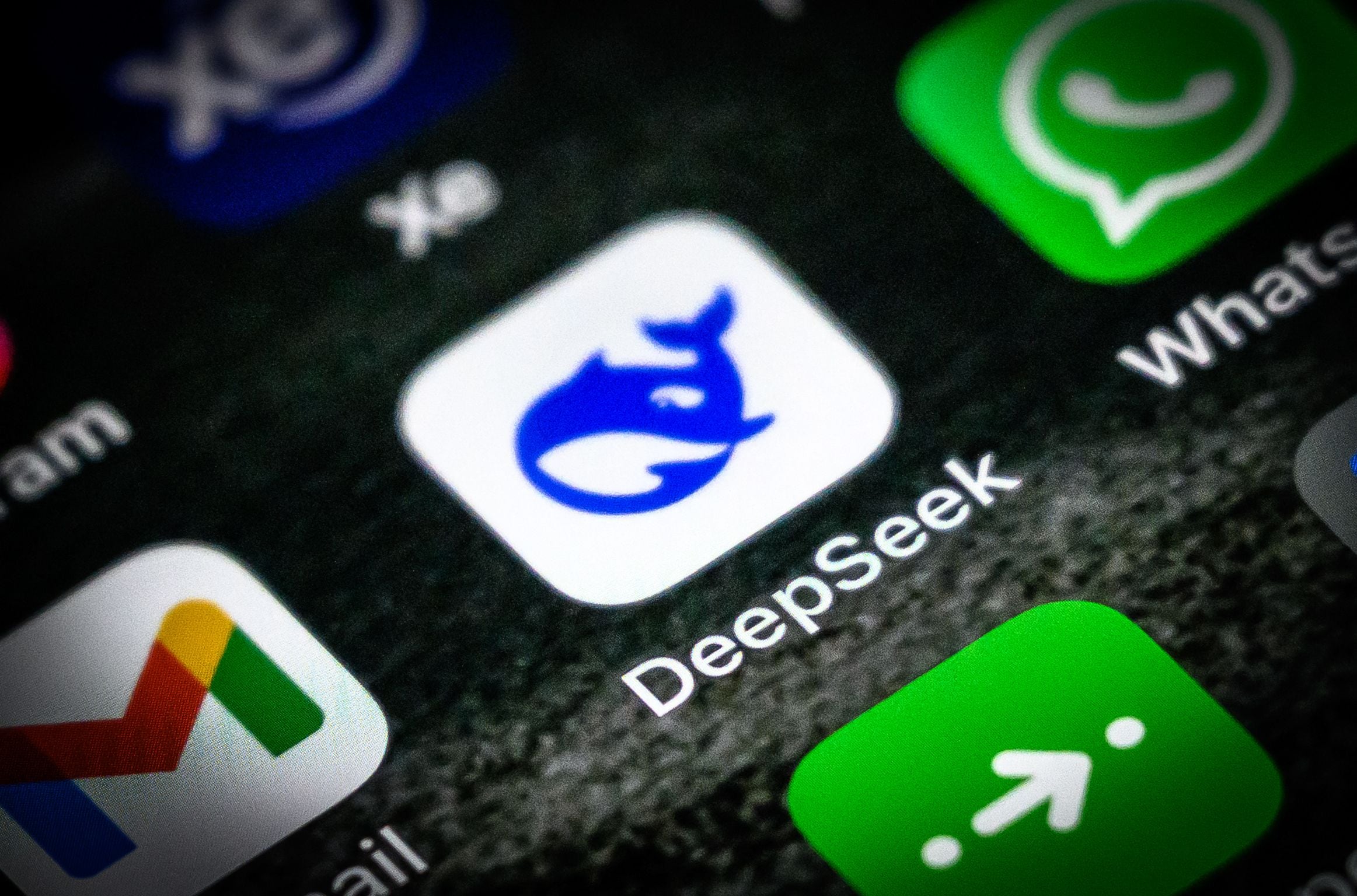 Icono de la aplicación DeepSeek visible en la pantalla de un teléfono móvil junto a otras apps populares como Gmail y WhatsApp.