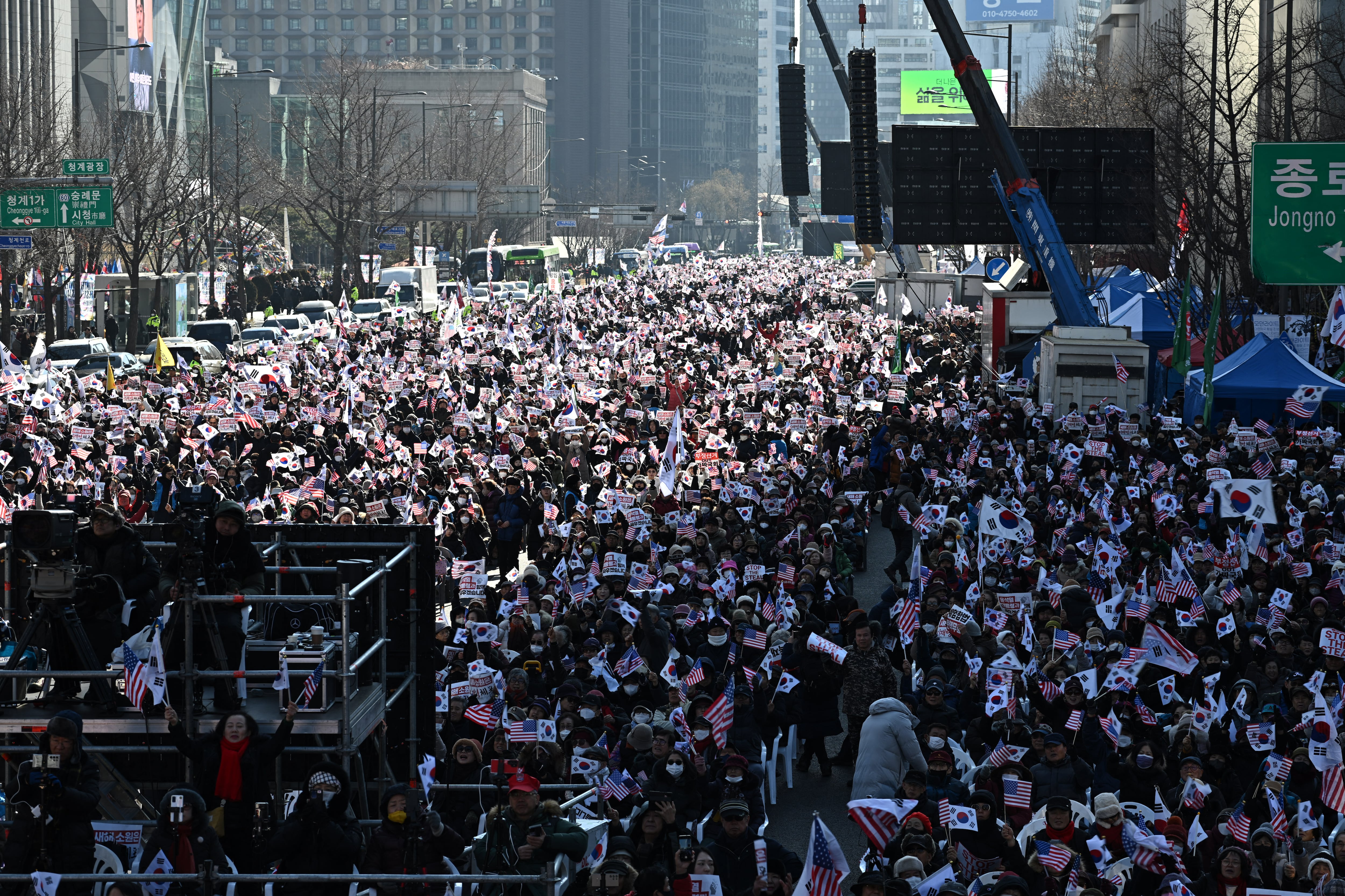 Multitud de personas ondea banderas de Estados Unidos y Corea del Sur durante una manifestación en apoyo al presidente suspendido Yoon Suk Yeol en el área de Gwanghwamun, Seúl, el 4 de enero de 2025.