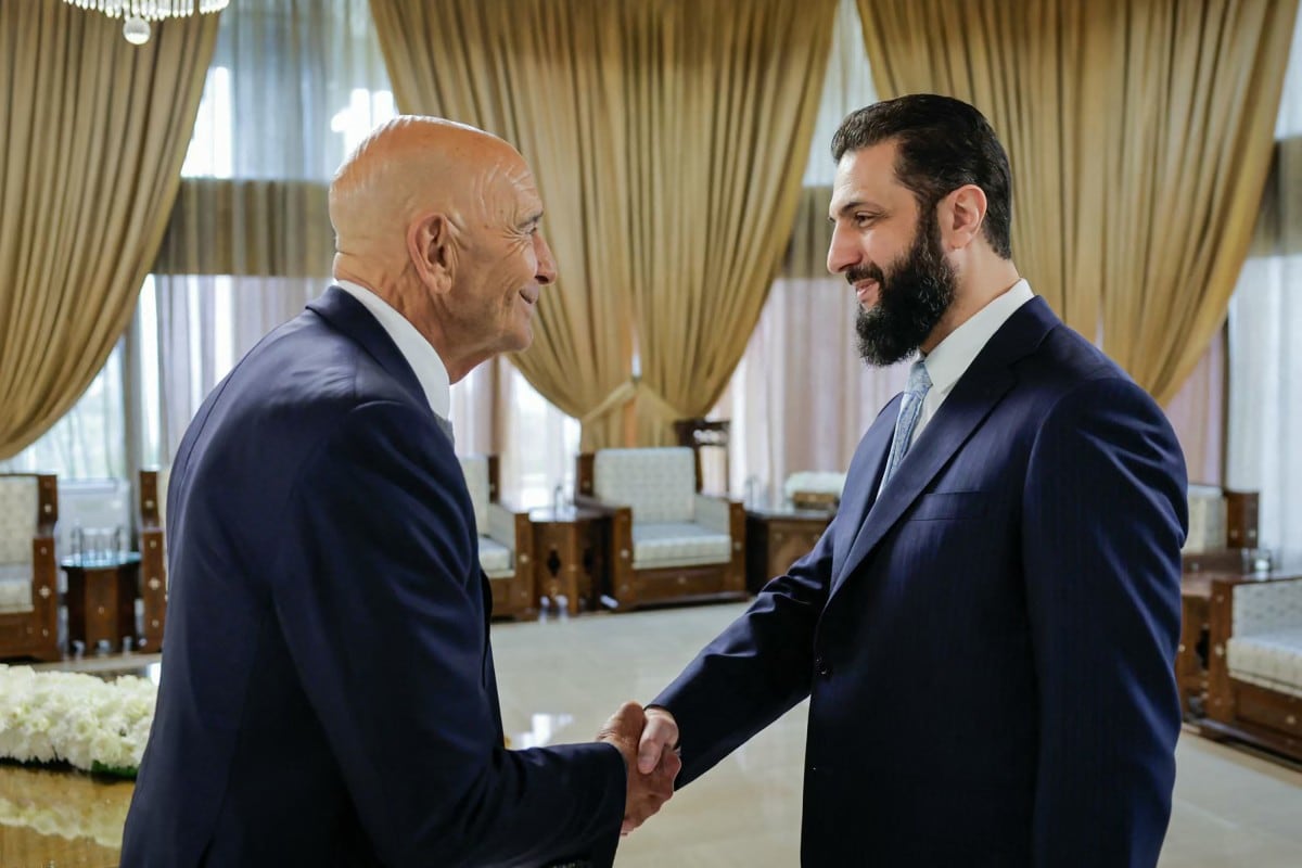 Esta fotografía, distribuida por la página de Telegram de la Presidencia siria, muestra al presidente de Siria, Ahmed al-Sharaa (derecha), estrechando la mano del enviado estadounidense Tom Barrack en el Palacio Presidencial de Damasco, en enero.
