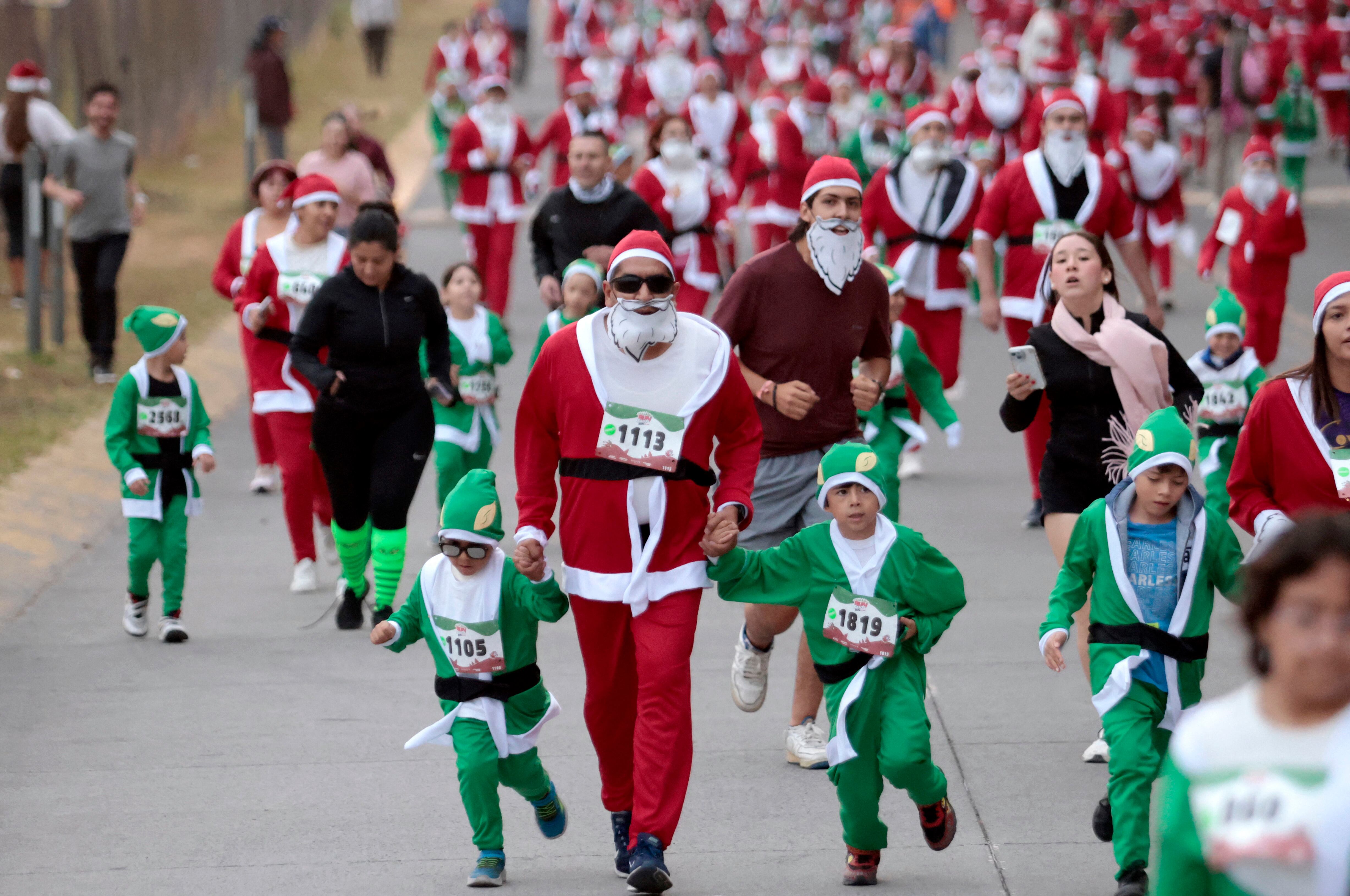 Multitud de corredores disfrazados de Santa Claus y elfos compiten en la carrera navideña 'Run Santa Run' en Zapopan, México, el 8 de diciembre de 2024.