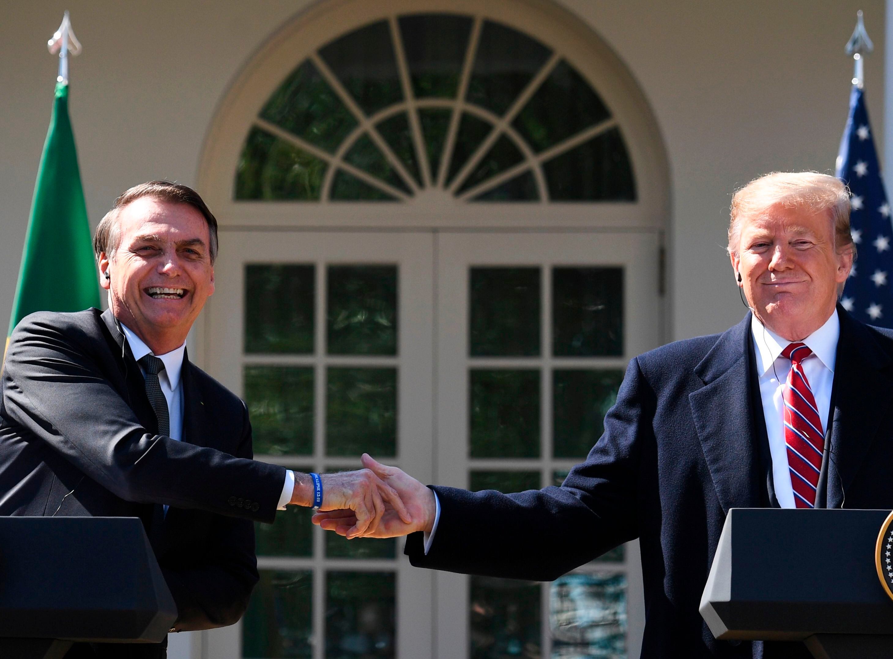 Donald Trump y Jair Bolsonaro estrechan manos durante una conferencia de prensa en el Jardín de Rosas de la Casa Blanca, marzo de 2019.