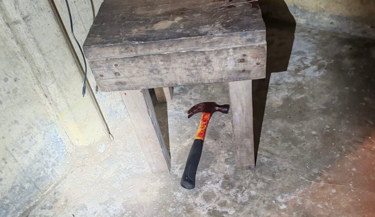 El martillo que habría utilizado el dueño de la casa se ubicó debajo de una mesa de madera.
