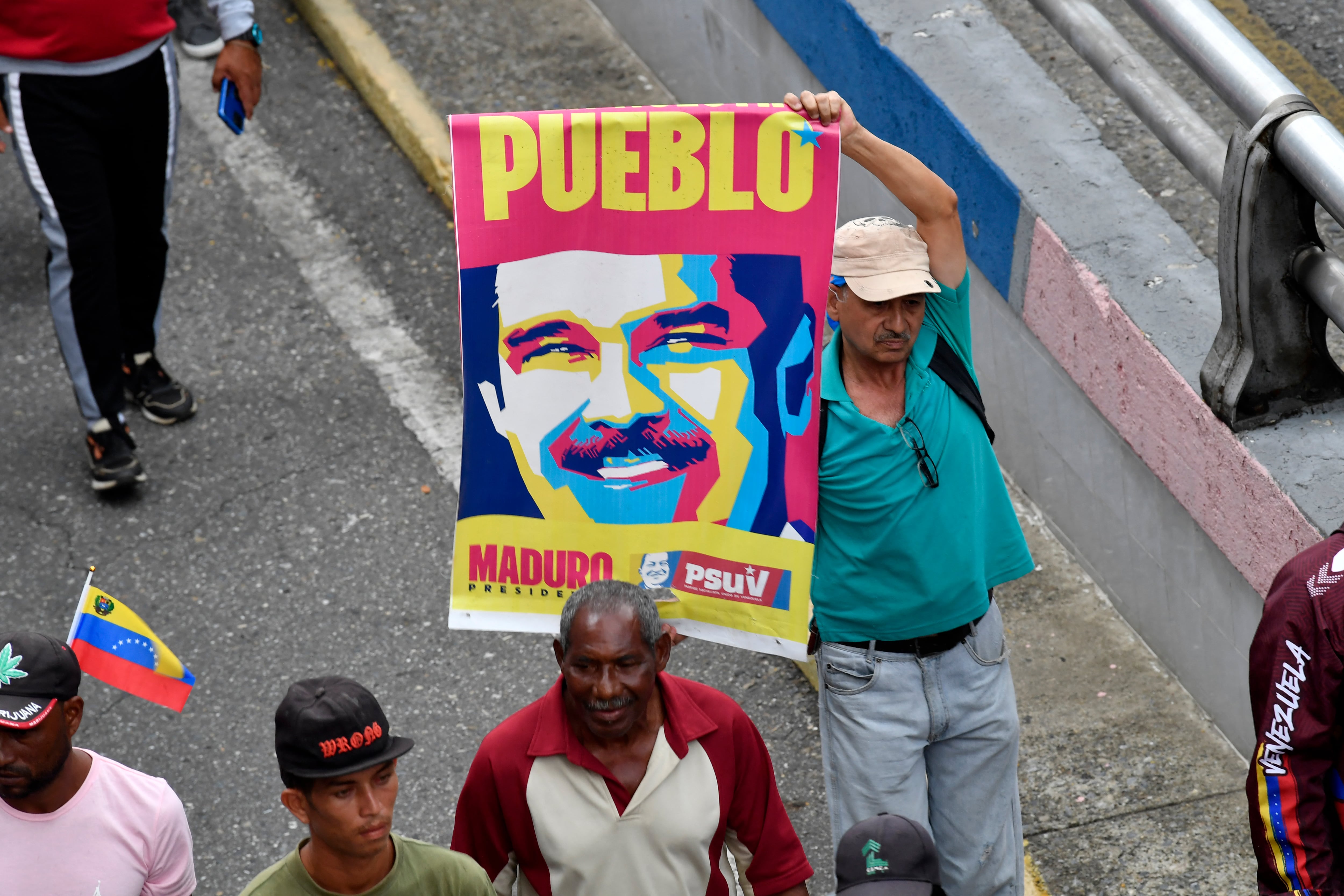 Un partidario de Nicolás Maduro sostiene un cartel electoral con la imagen de Maduro durante una manifestación que se dirige al palacio presidencial de Miraflores.