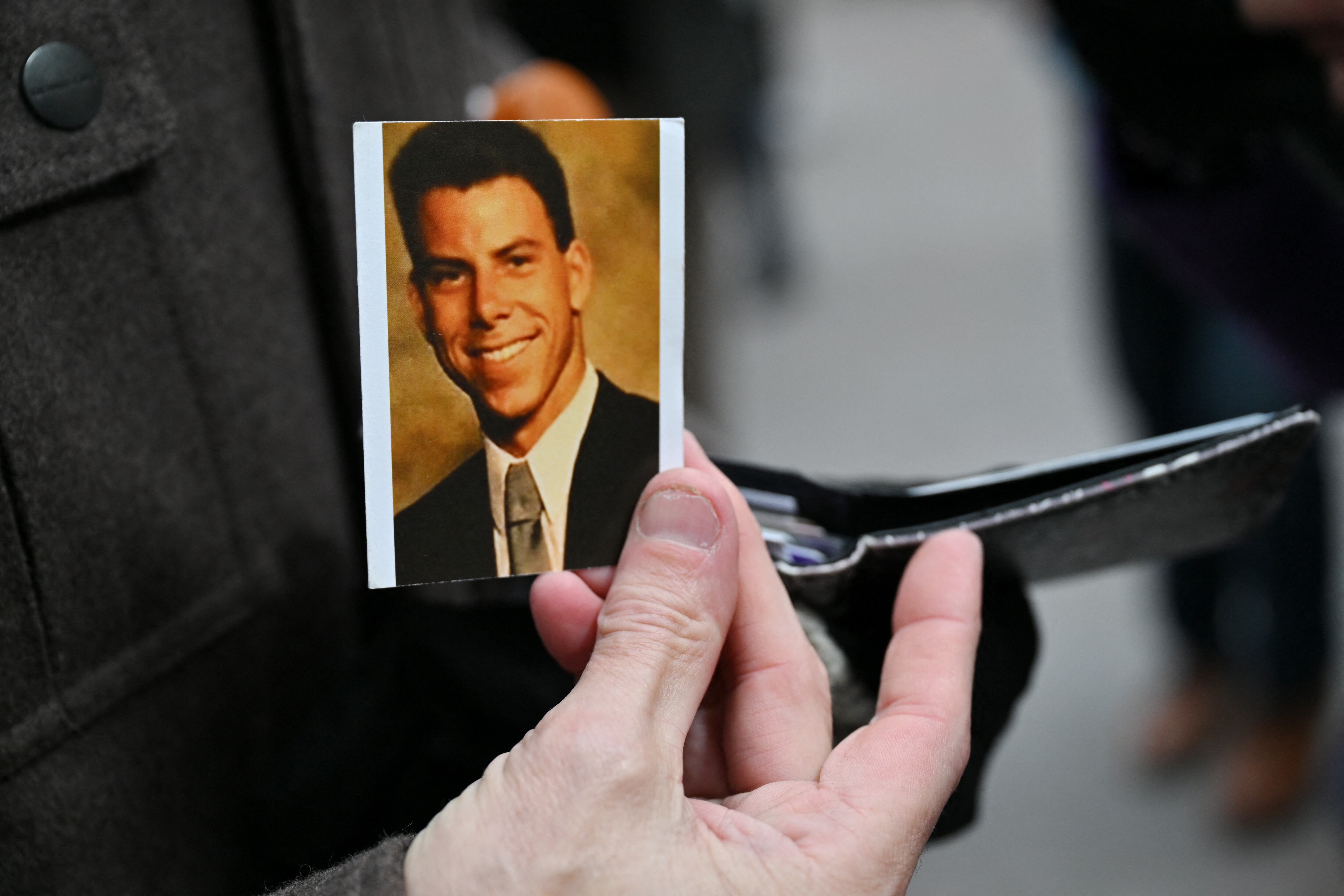 Nick Bonanno sostiene una fotografía escolar de Erik Menéndez frente al tribunal de Van Nuys antes de una audiencia sobre la condena por asesinato de los hermanos Menéndez el 25 de noviembre de 2024.