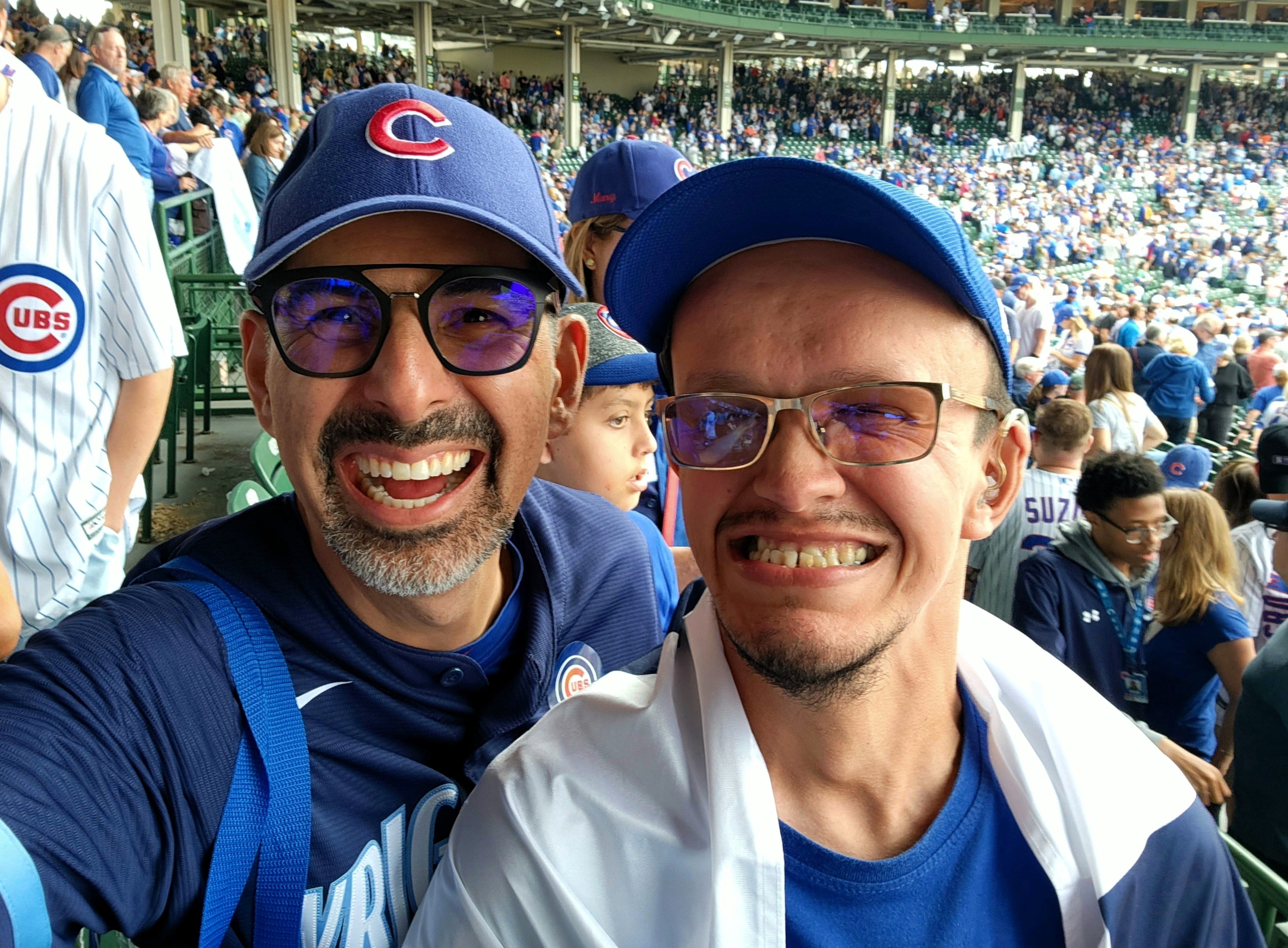 Esteban, joven de 30 años, sordo desde niño, en Chicago, viendo jugar a los Cubs. Lo acompaña el médico urólogo Andrés Arley.