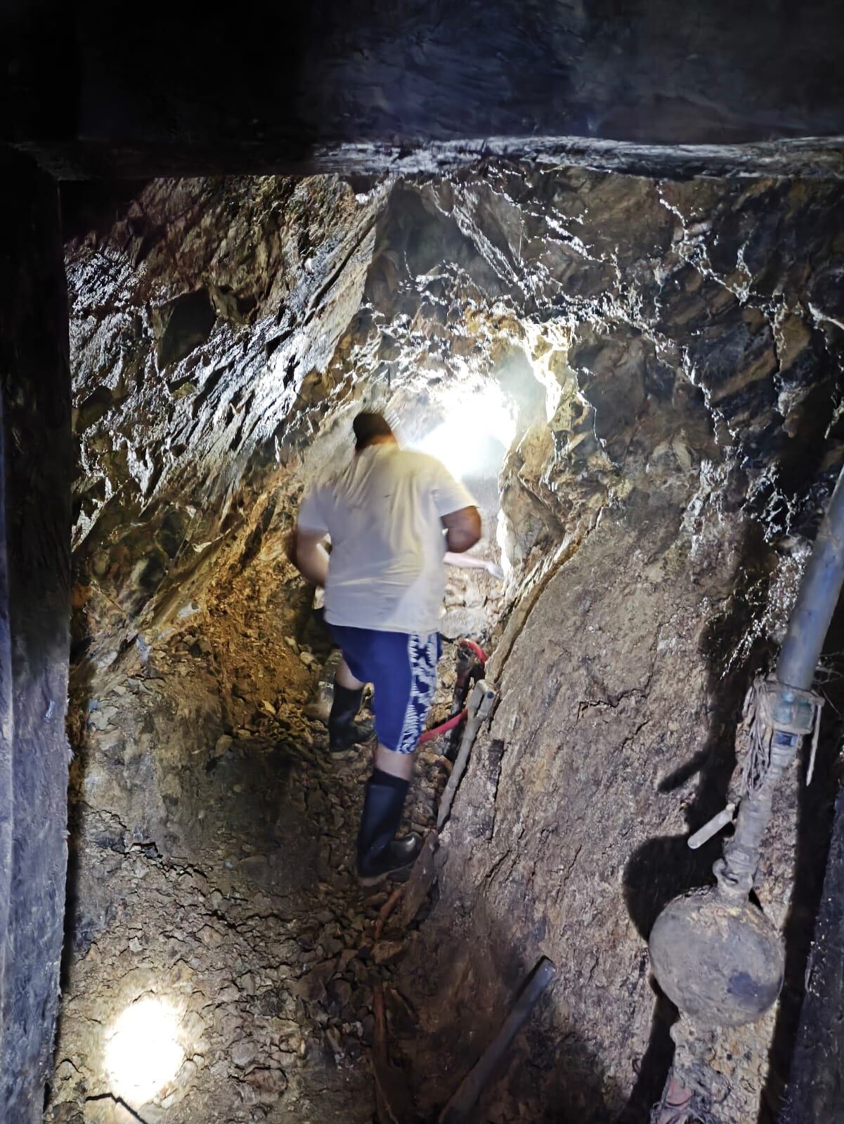 Un hombre camina entre las estrechas paredes de piedra de la mina en la que dos hombres quedaron atrapados, en Miramar de Puntarenas.